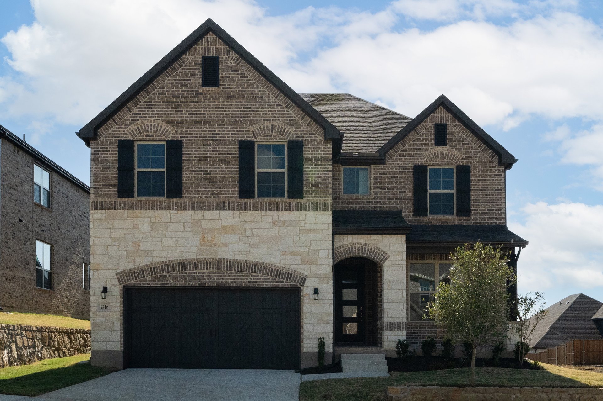 exterior of home with brown brick and tan stone