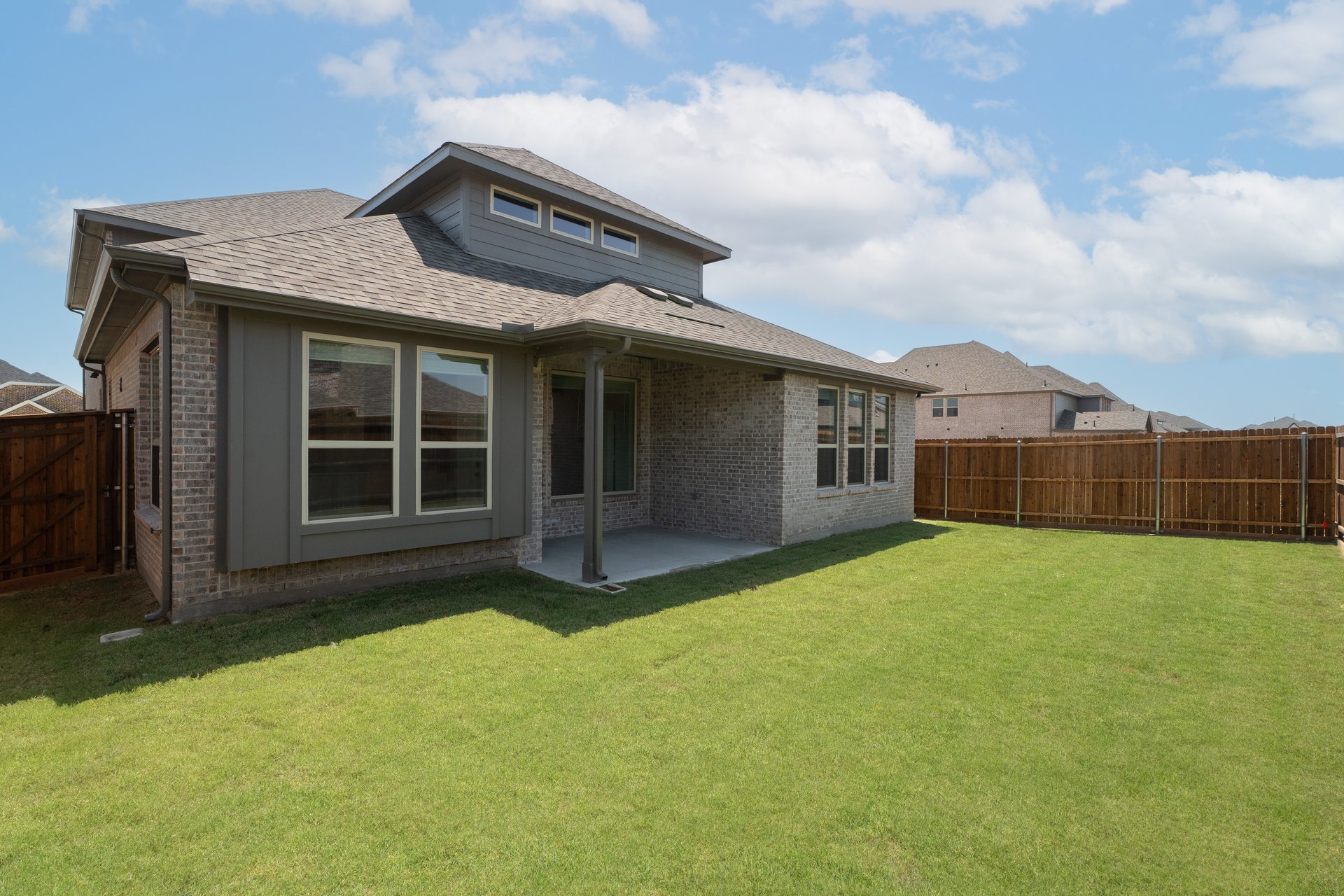covered patio that opens to fenced backyard