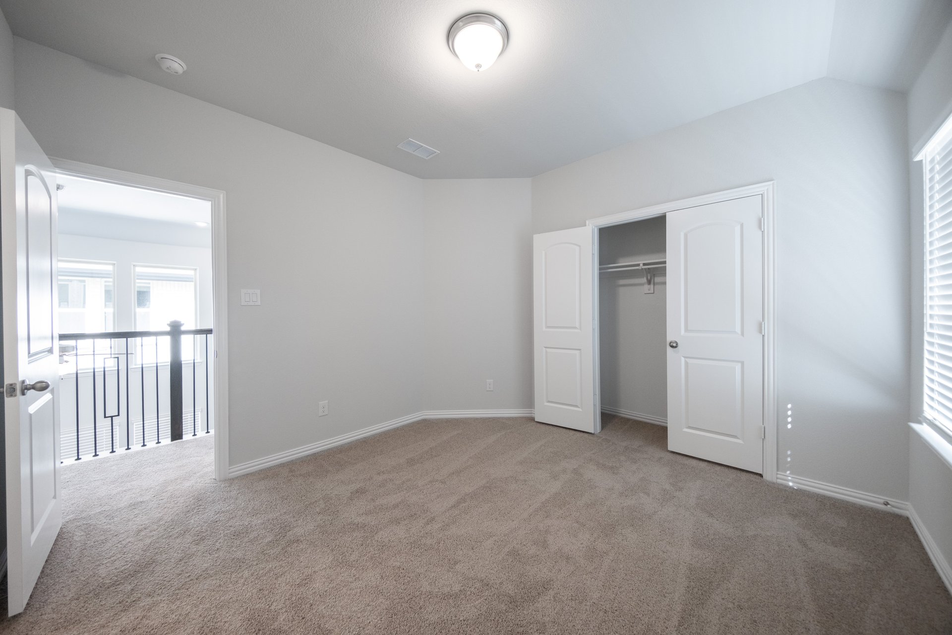 guest bedroom with carpet and window