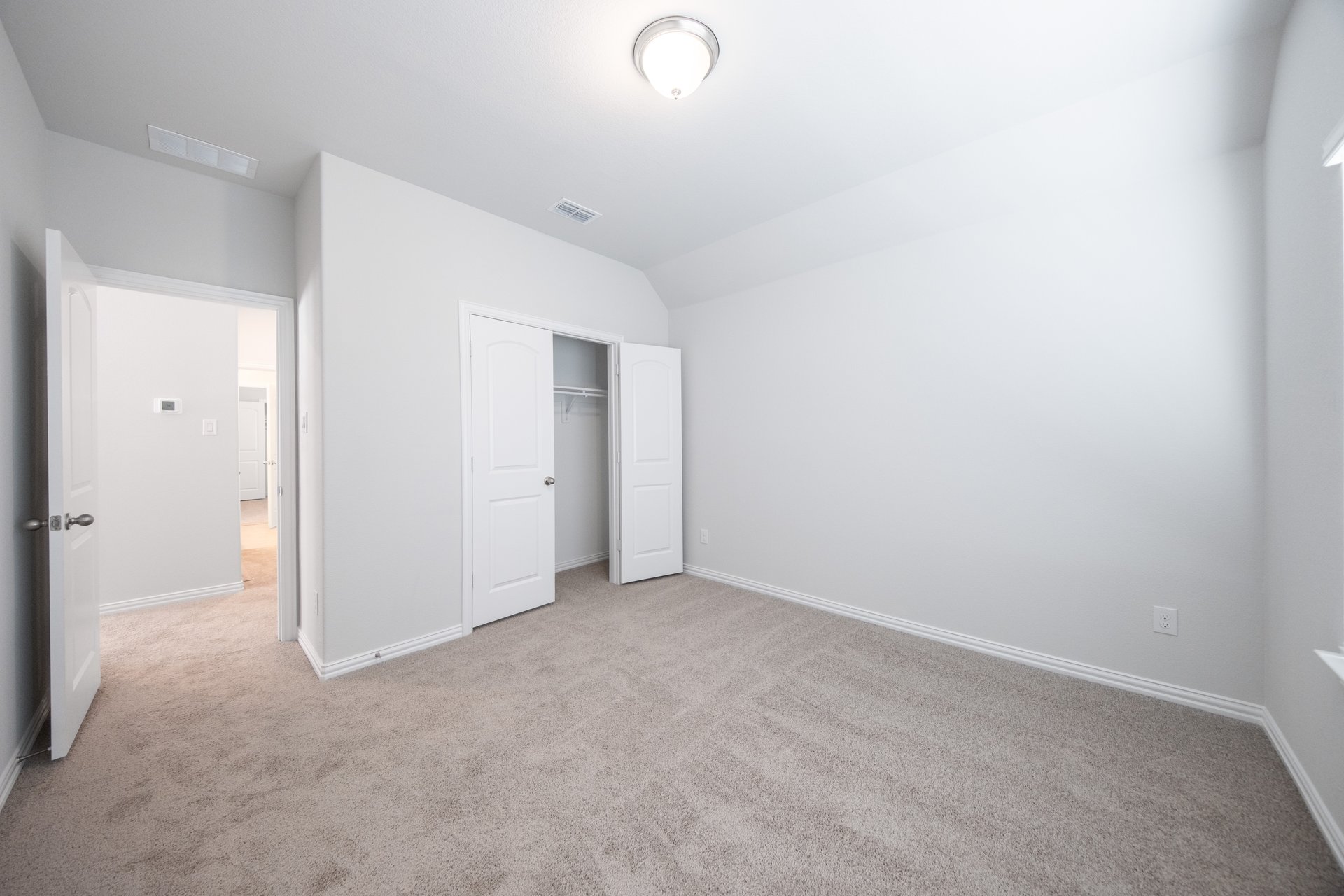 guest bedroom with carpet and window
