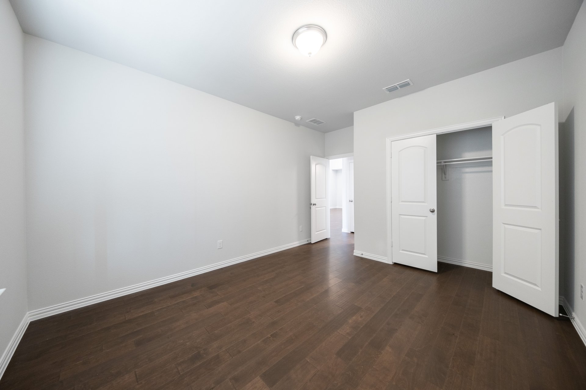 guest bedroom with hardwood flooring