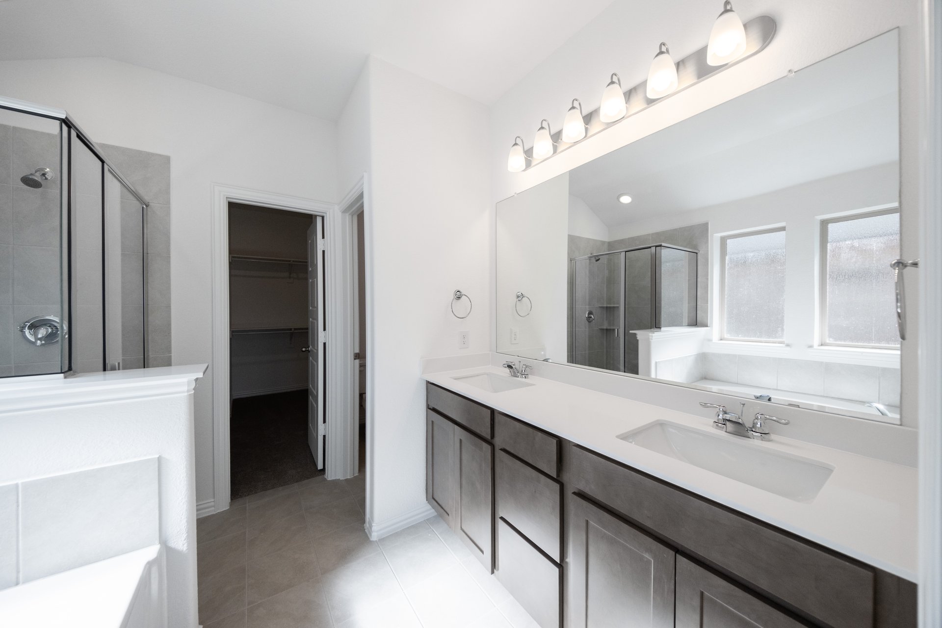 bathroom with dark cabinets and white countertops