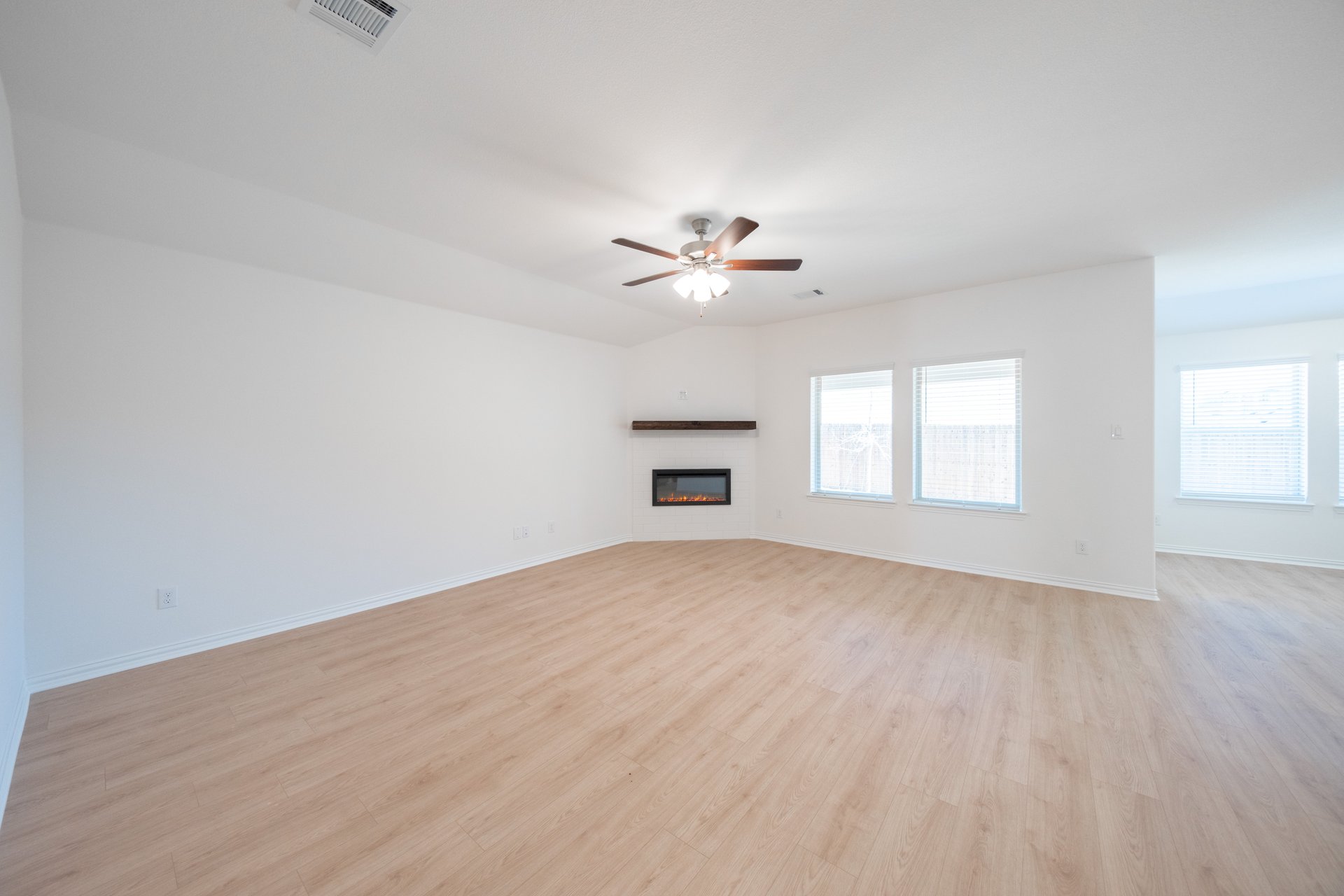 open great room with hardwood flooring and gas fireplace