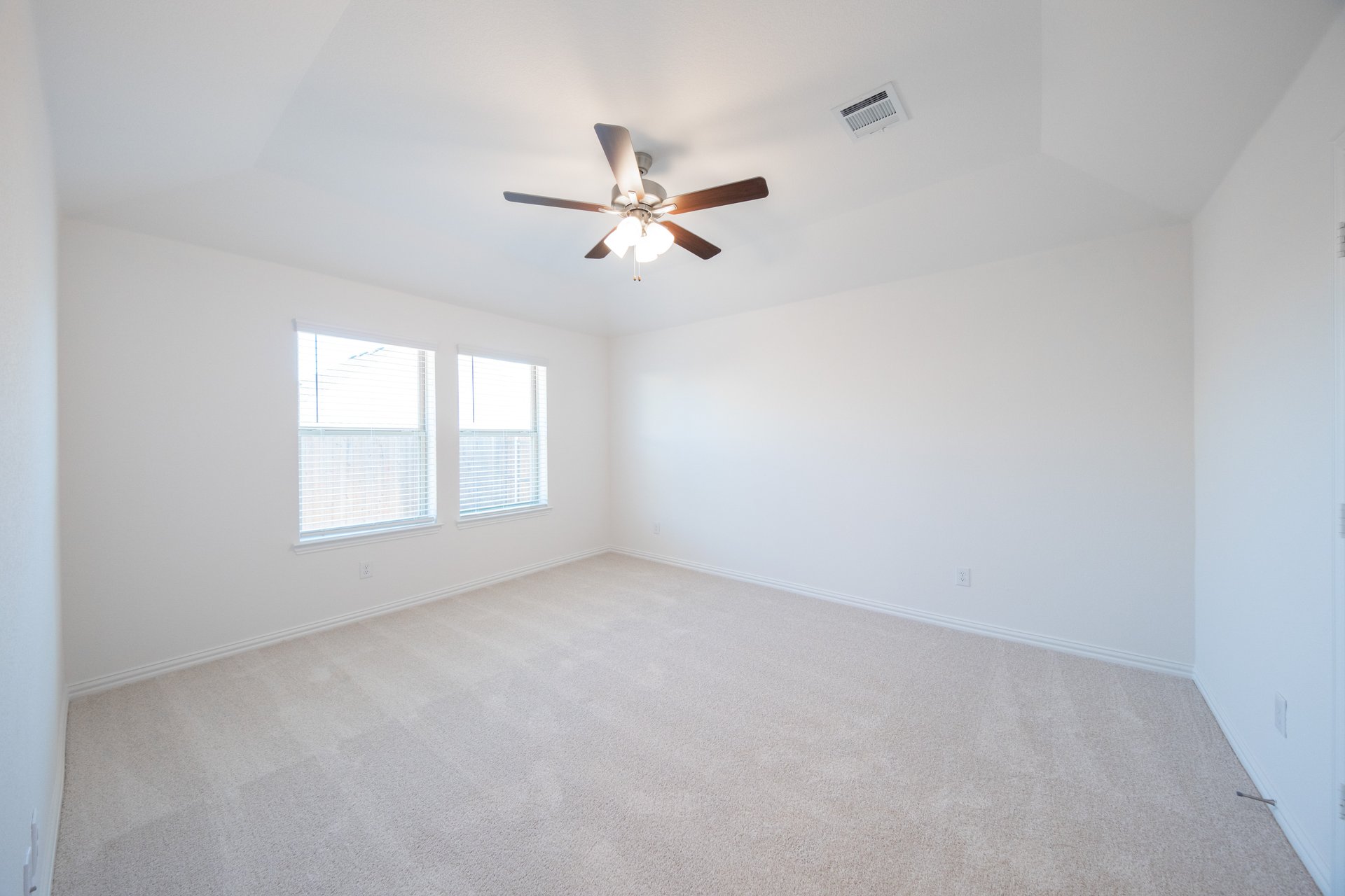 spacious primary bedroom with ceiling fan