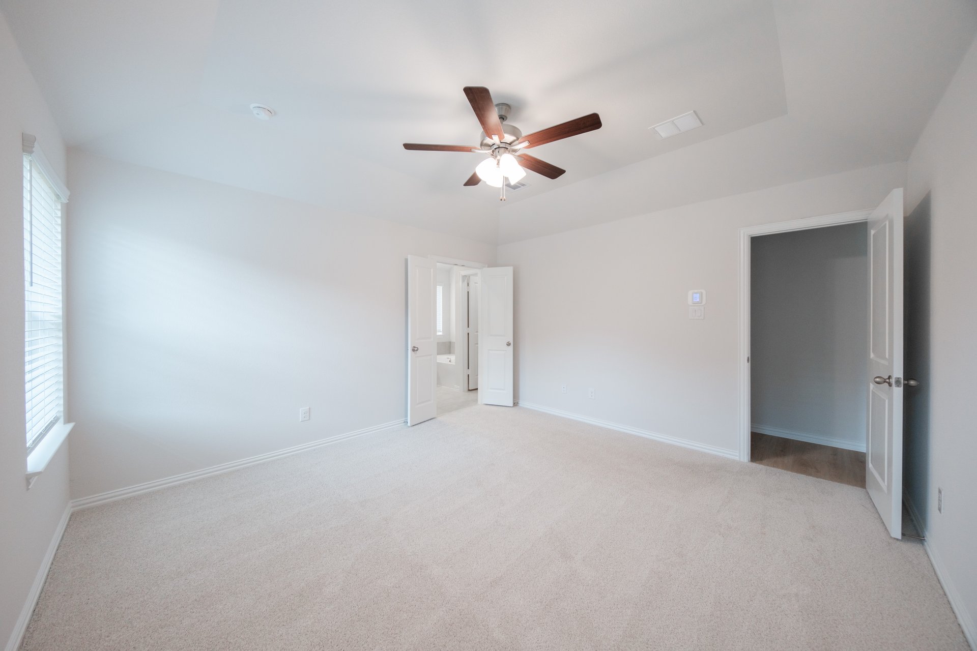 primary bedroom with carpet and ceiling fan