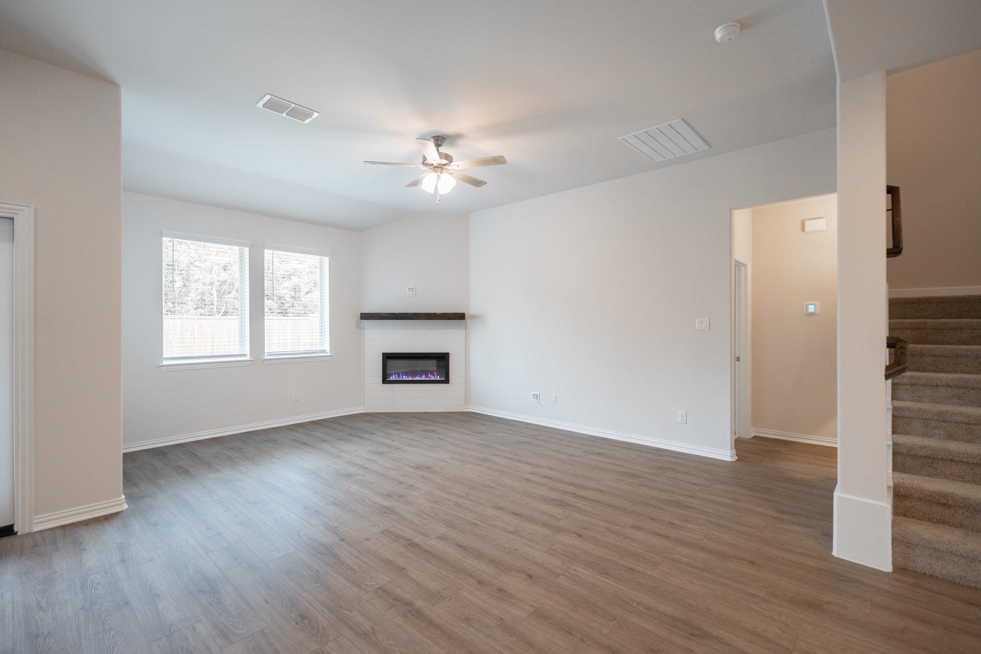 open great room with wood floors and fireplace