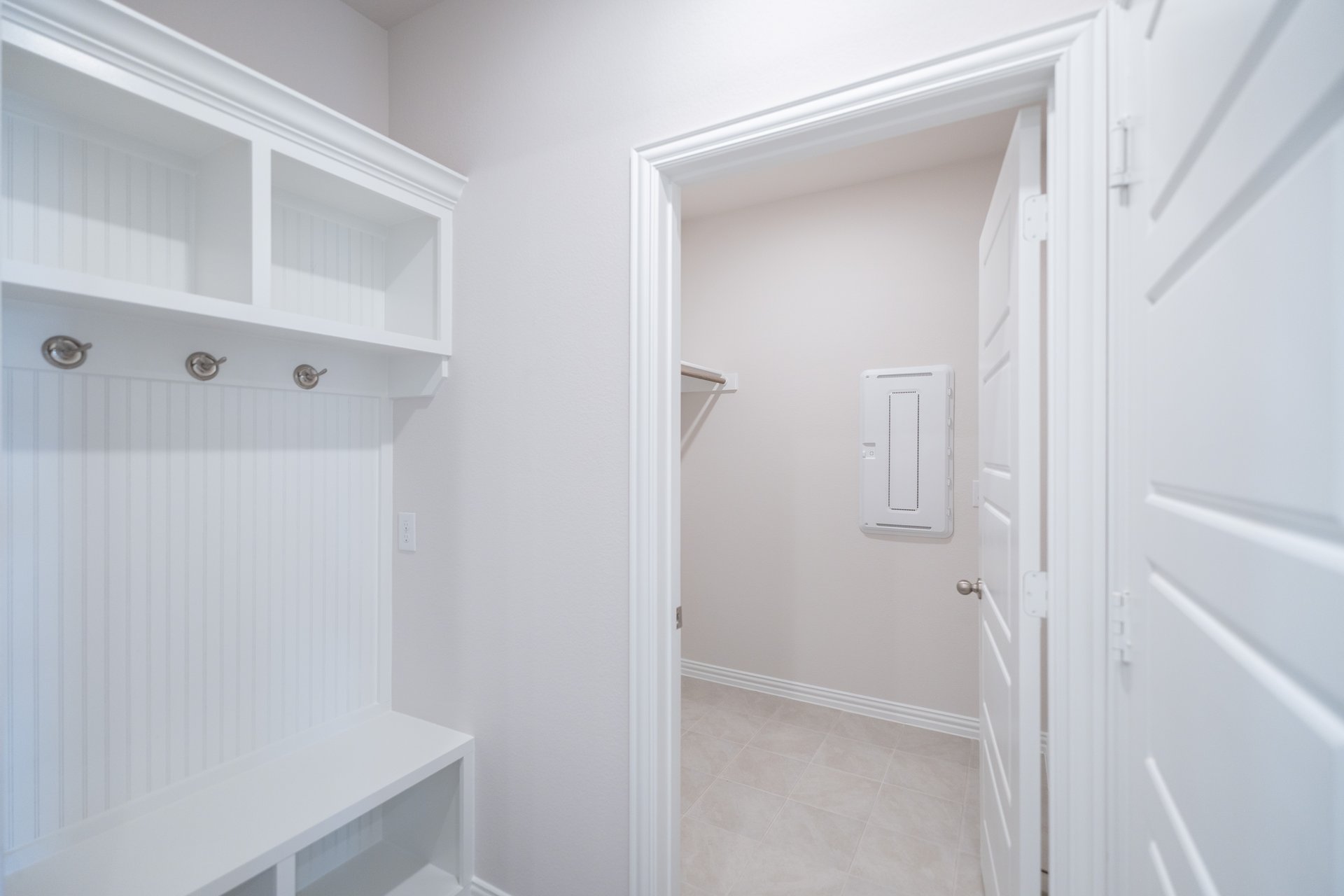 laundry room with tile floors and white shelf