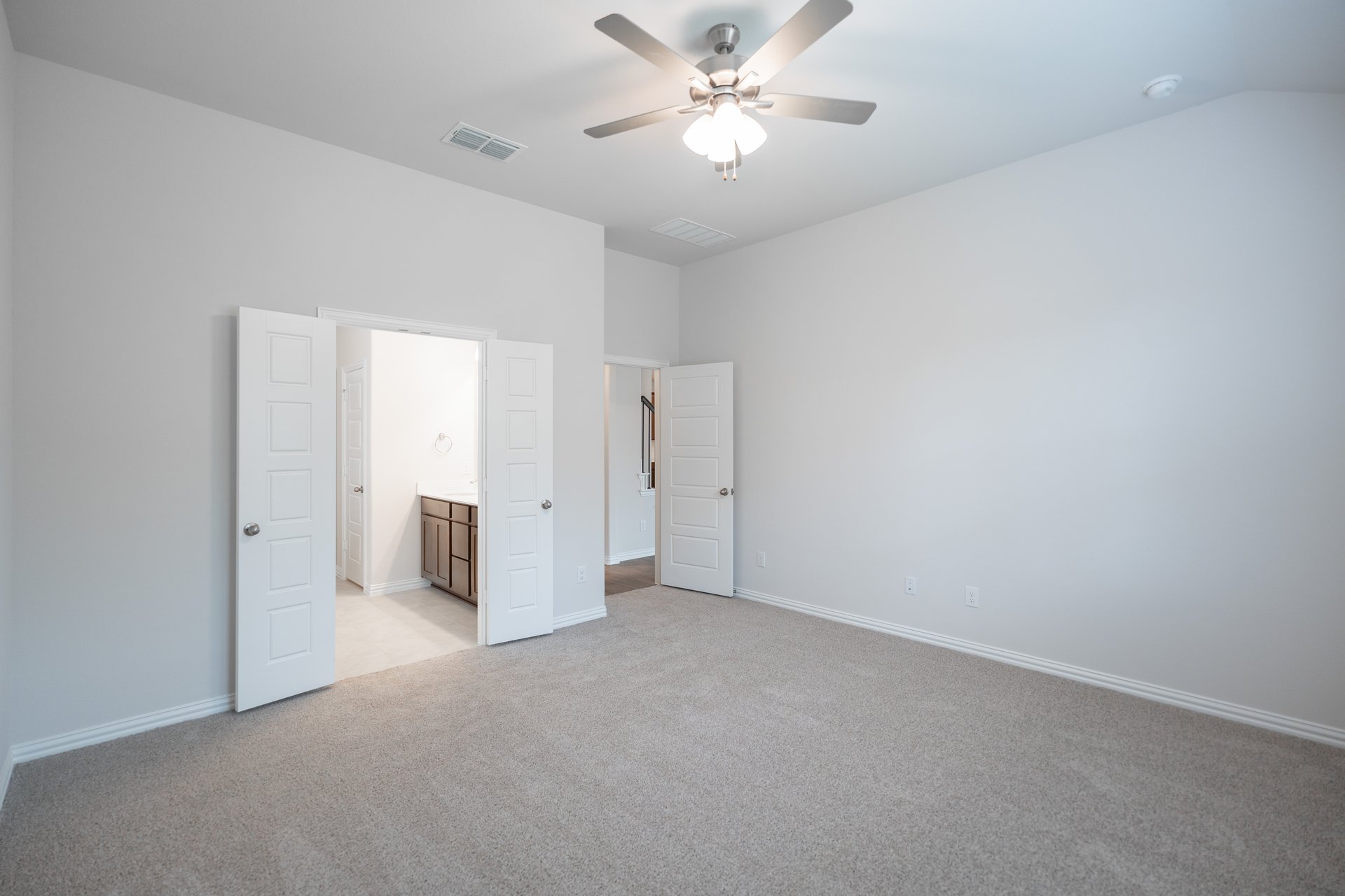 primary bedroom with carpet and ceiling fan