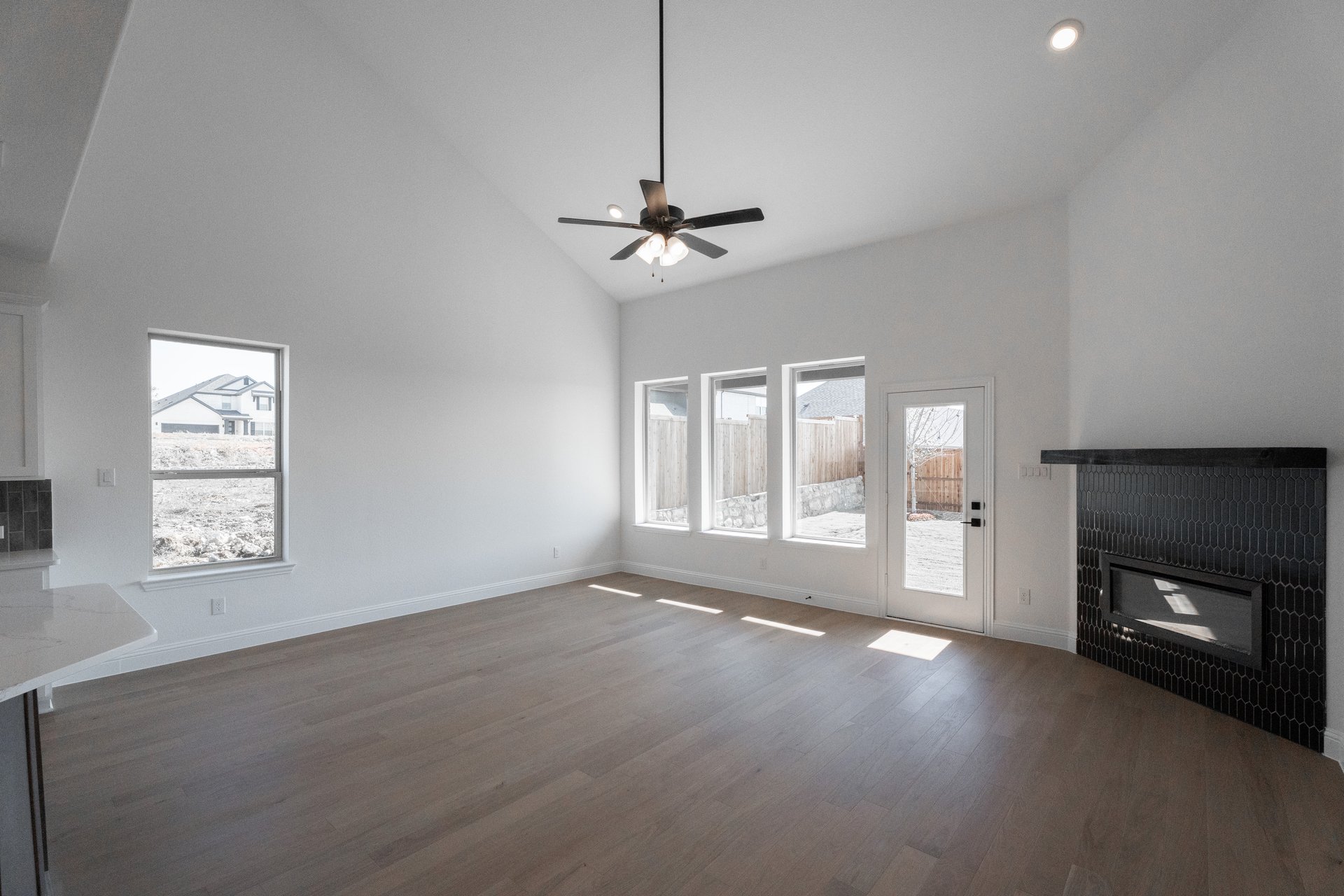 great room with large windows and wood flooring