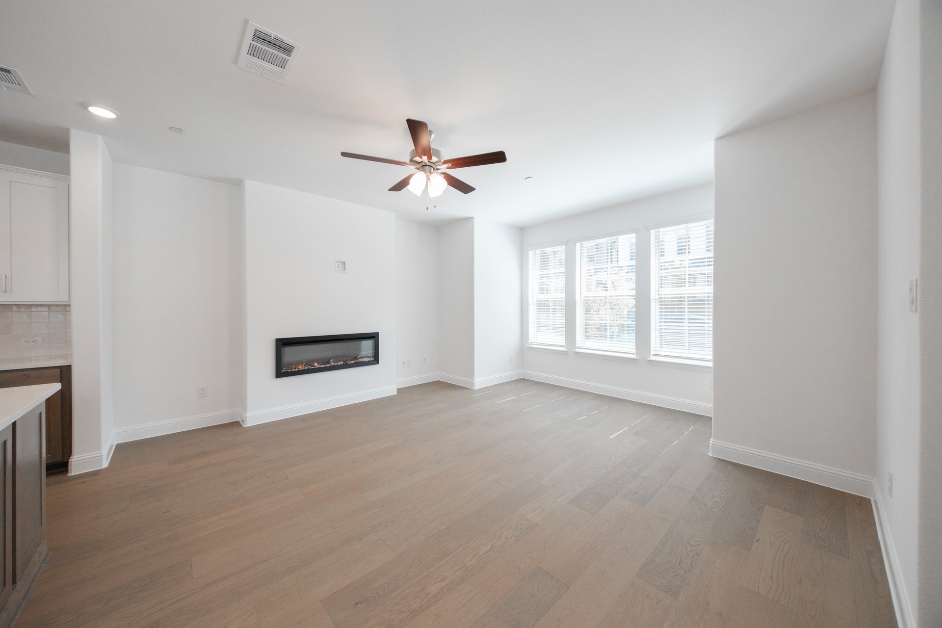open great room with wood floors and fireplace