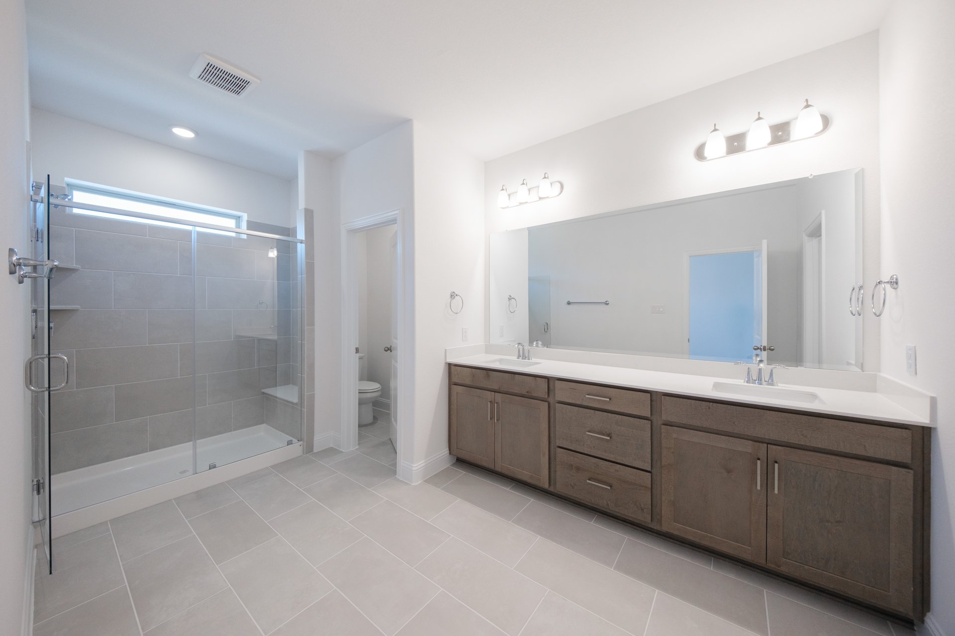 primary bathroom with walk-in shower and tile floors