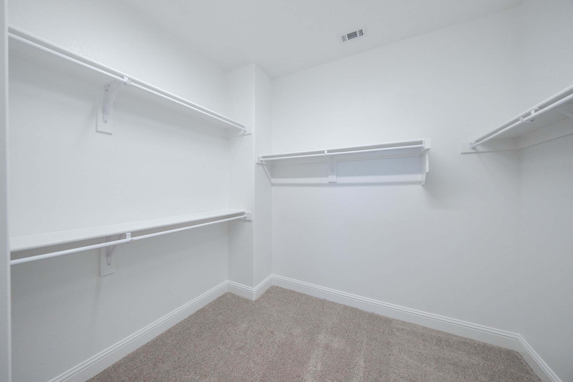 primary bedroom closet with carpet and white shelves