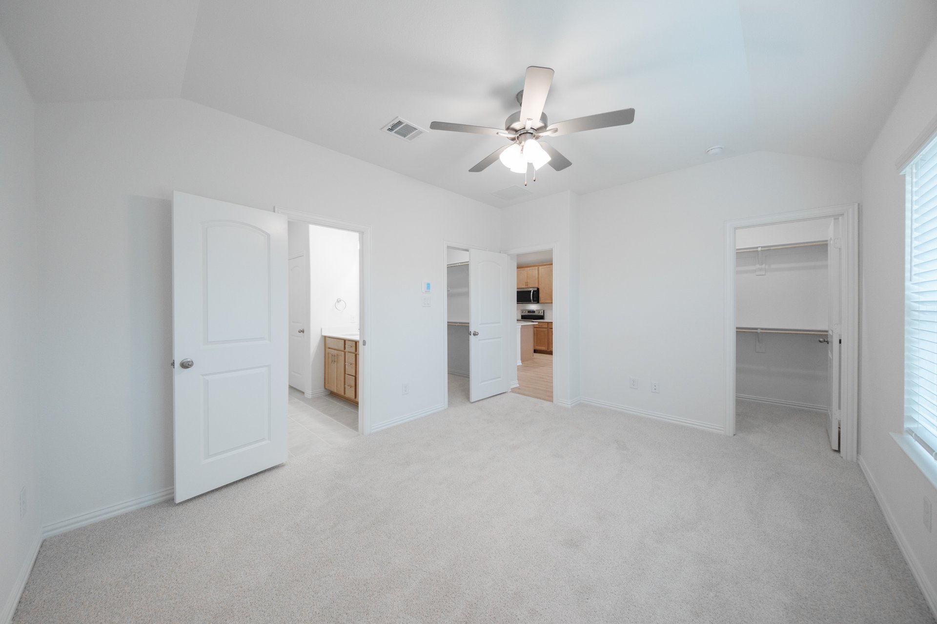 primary bedroom with carpet and ceiling fan
