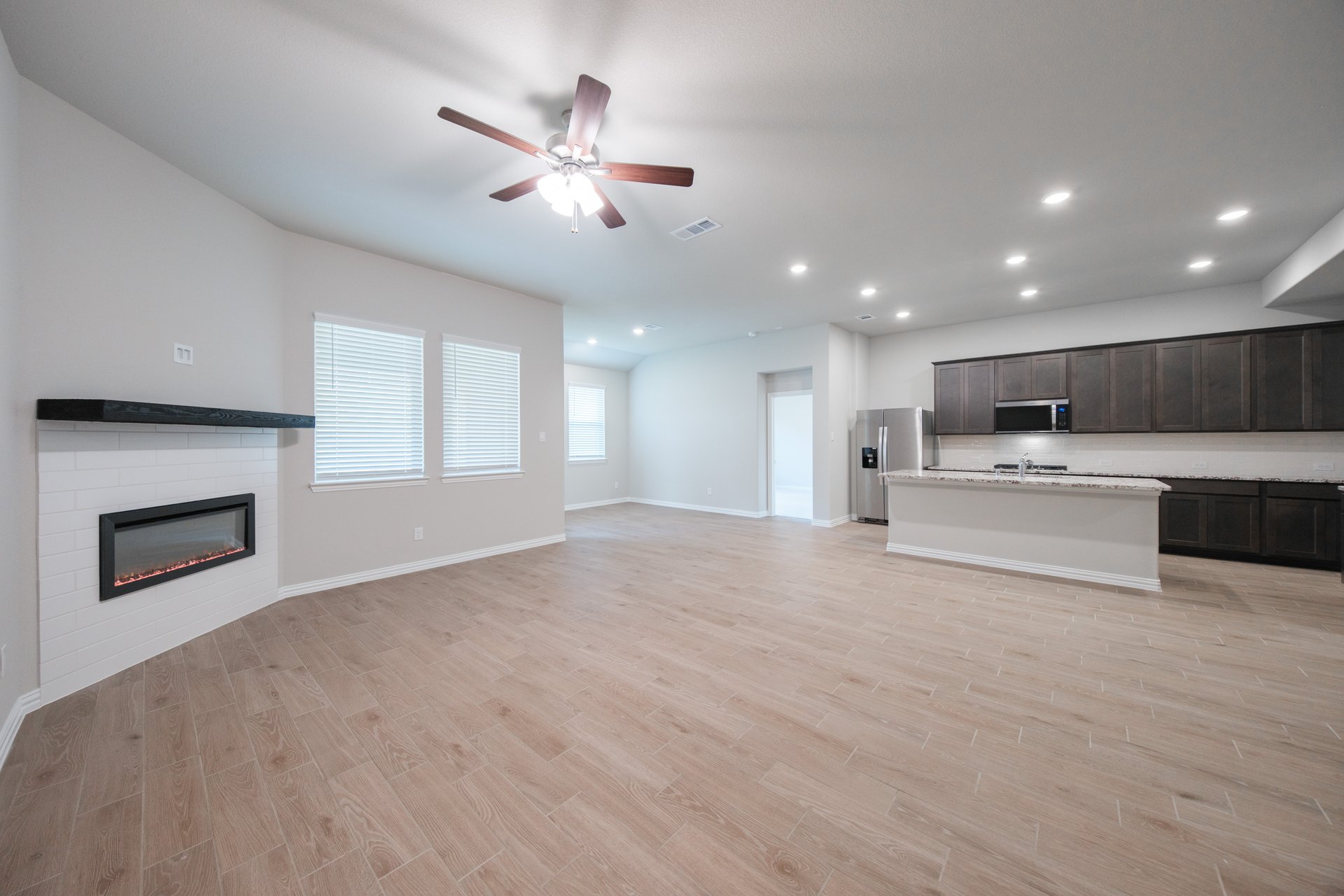 open great room with wood floors and ceiling fan