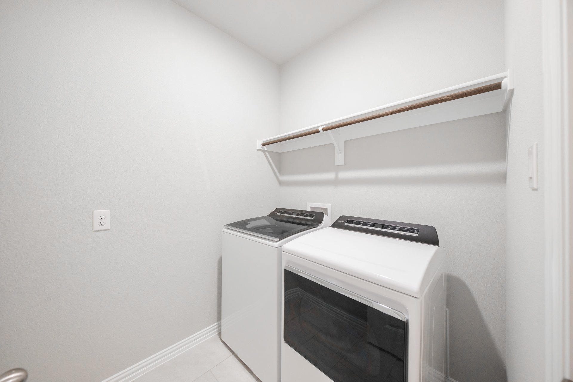 laundry room with tile floors and white shelf
