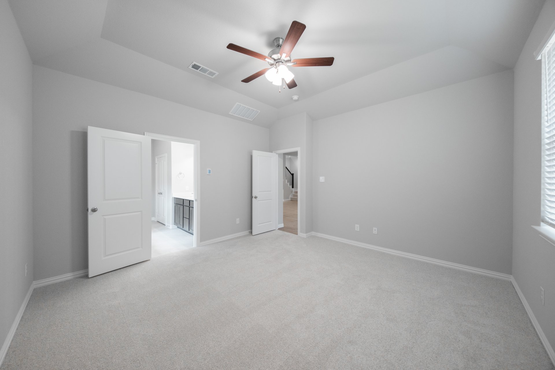 primary bedroom with carpet and ceiling fan
