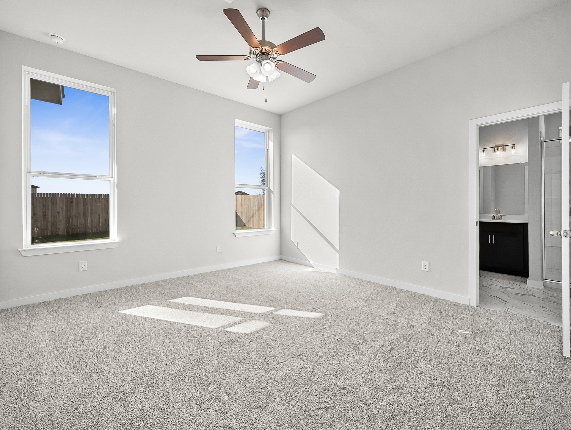 bedroom with carpet, ceiling fan & windows