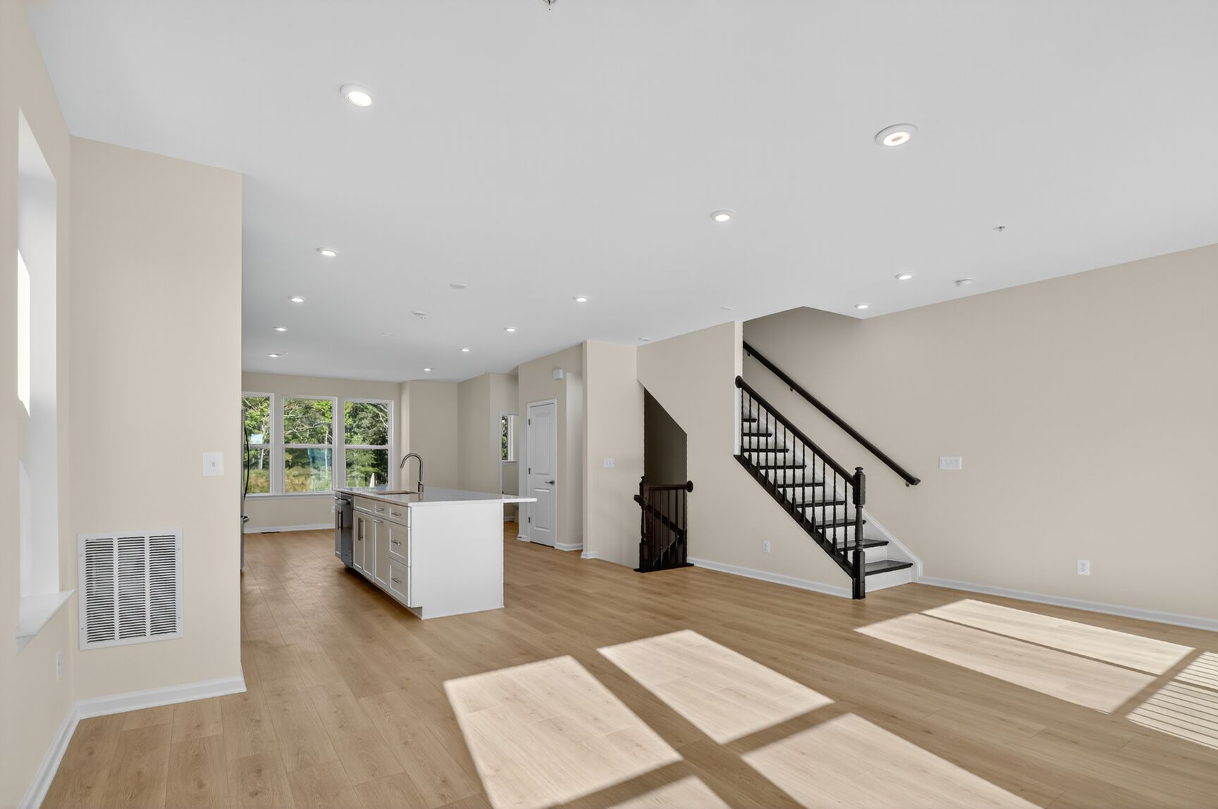 great room with designer flooring and oak tread stairs to upstairs