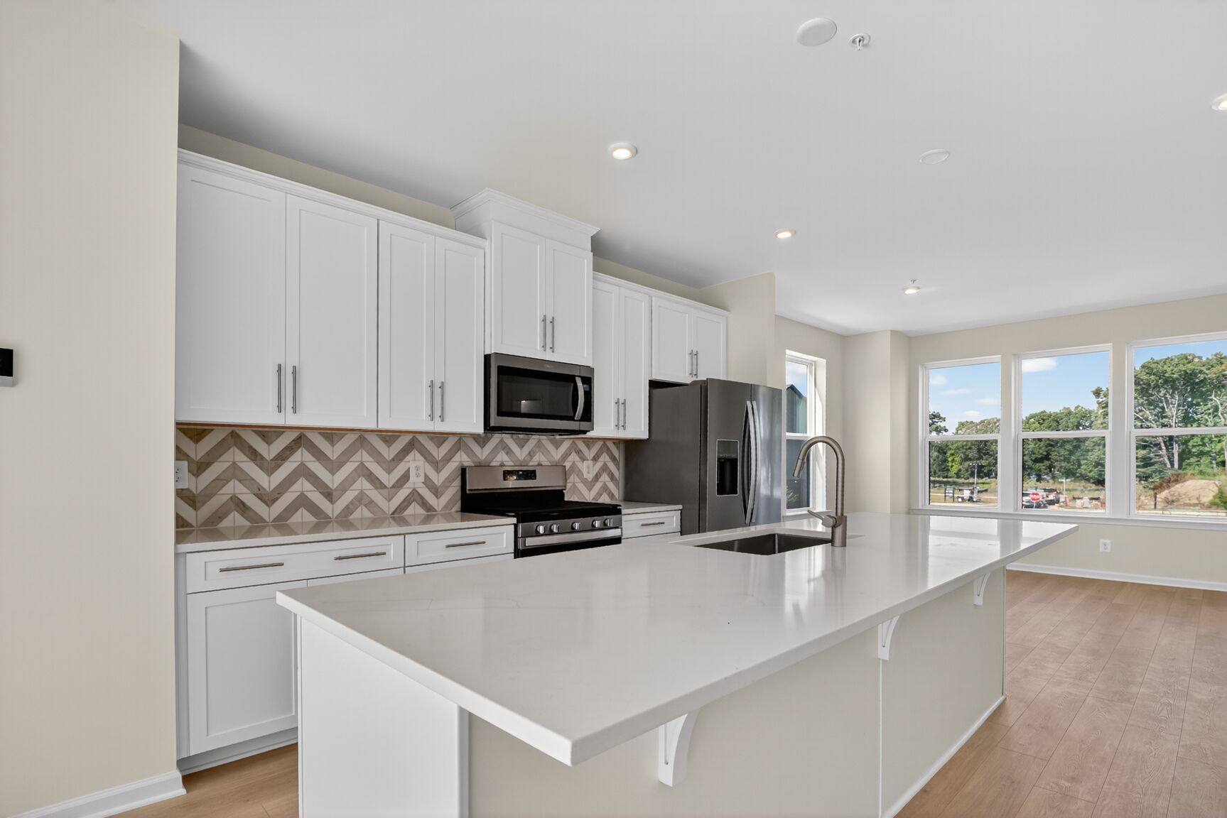 designer kitchen with bright white cabinetry and expansive island 