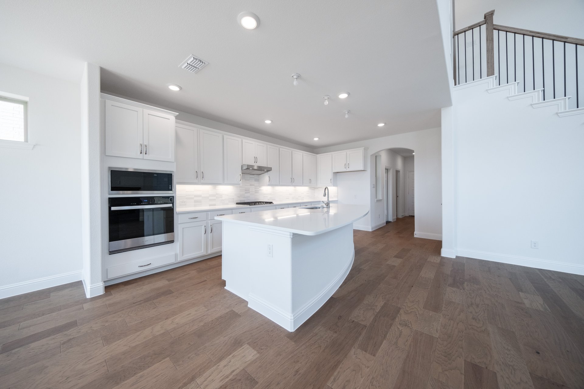 open kitchen with white cabinets and hardwood flooring