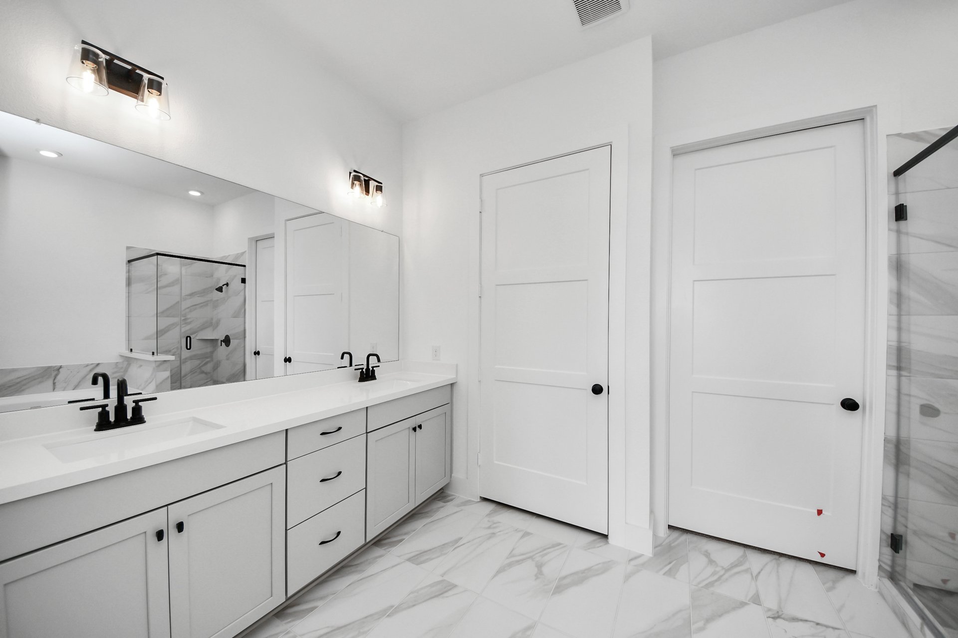 light colored flooring and vanity with dual sinks