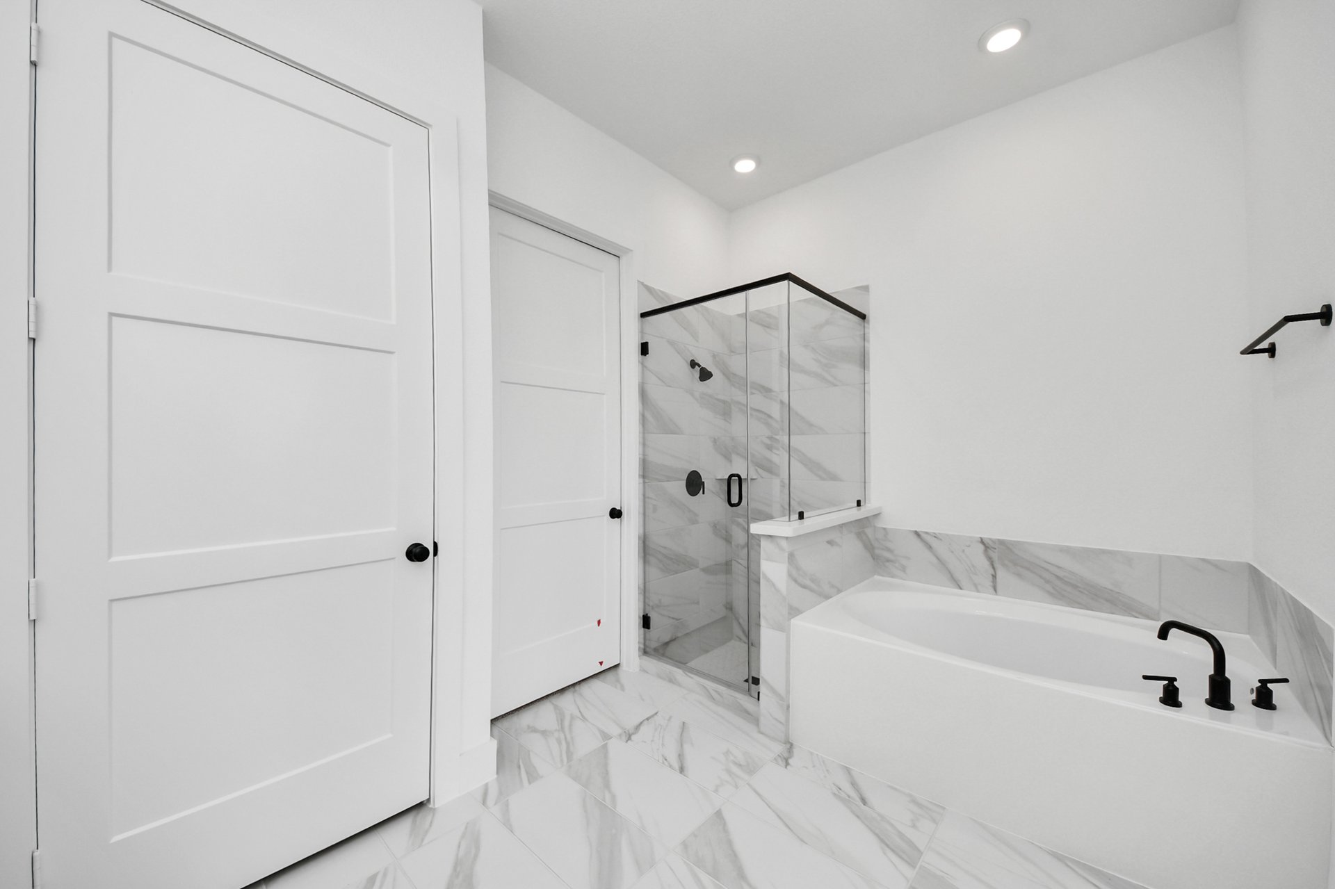 light colored tile surrounds tub and shower