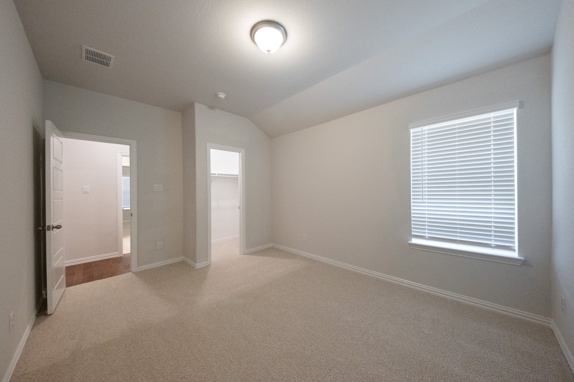 guest bedroom with carpet and walk-in closet