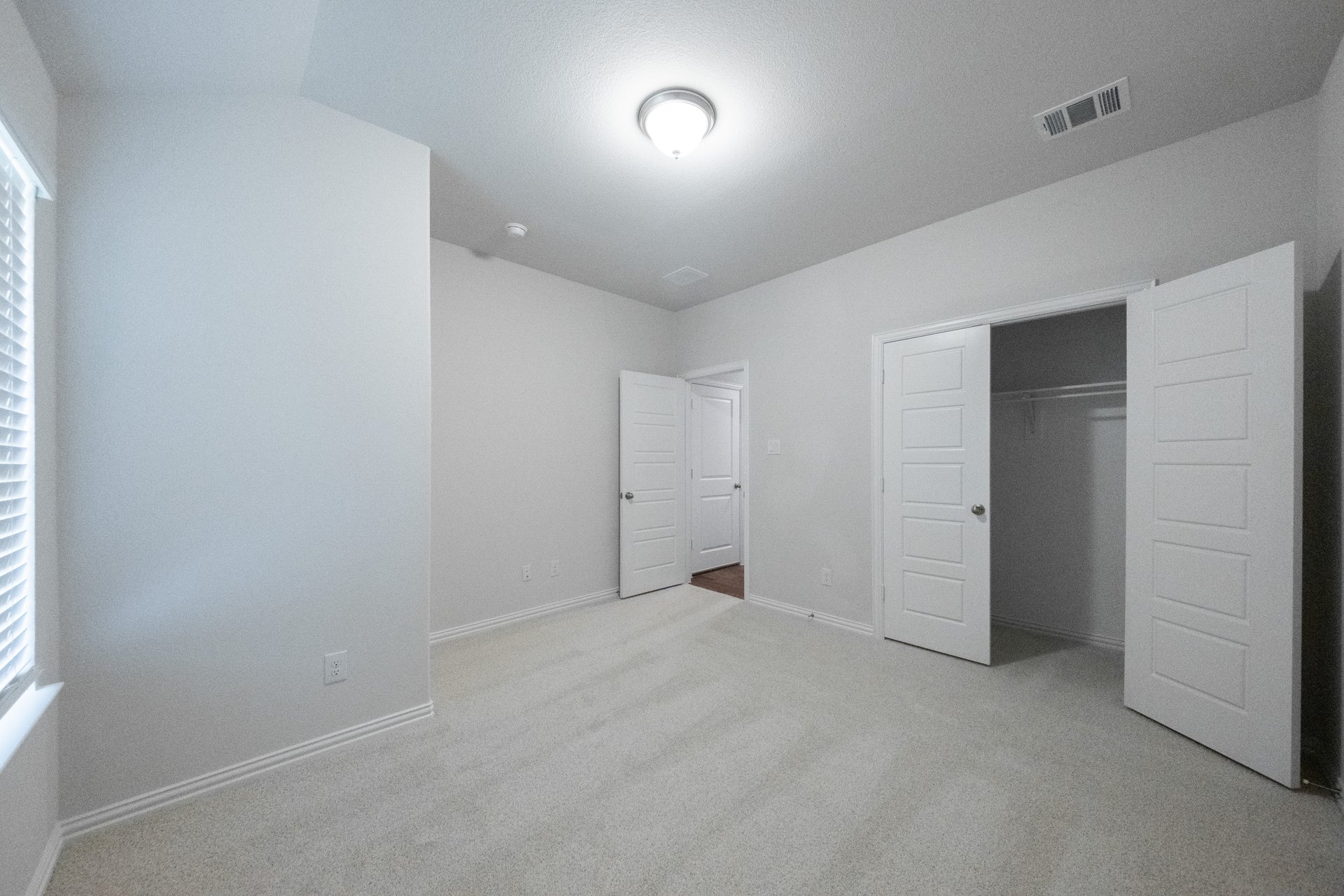 guest bedroom with carpet and walk-in closet