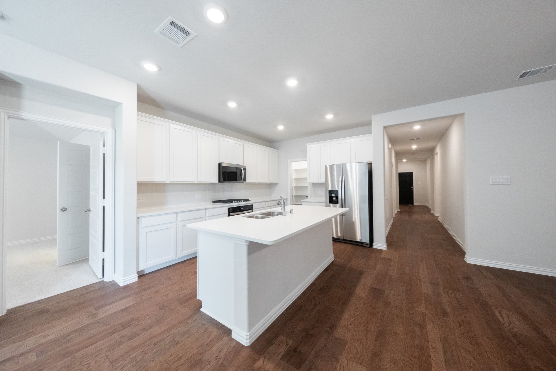 open kitchen with white cabinets and hardwood flooring