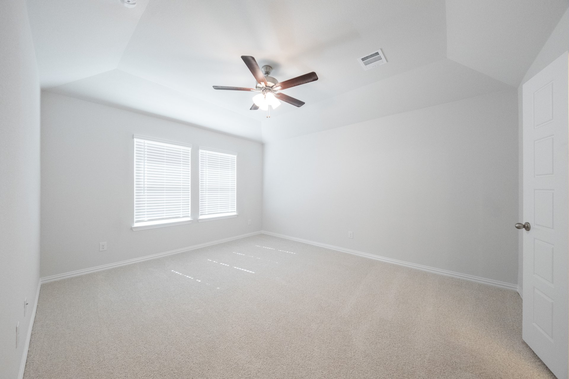 spacious primary bedroom with carpet and ceiling fan
