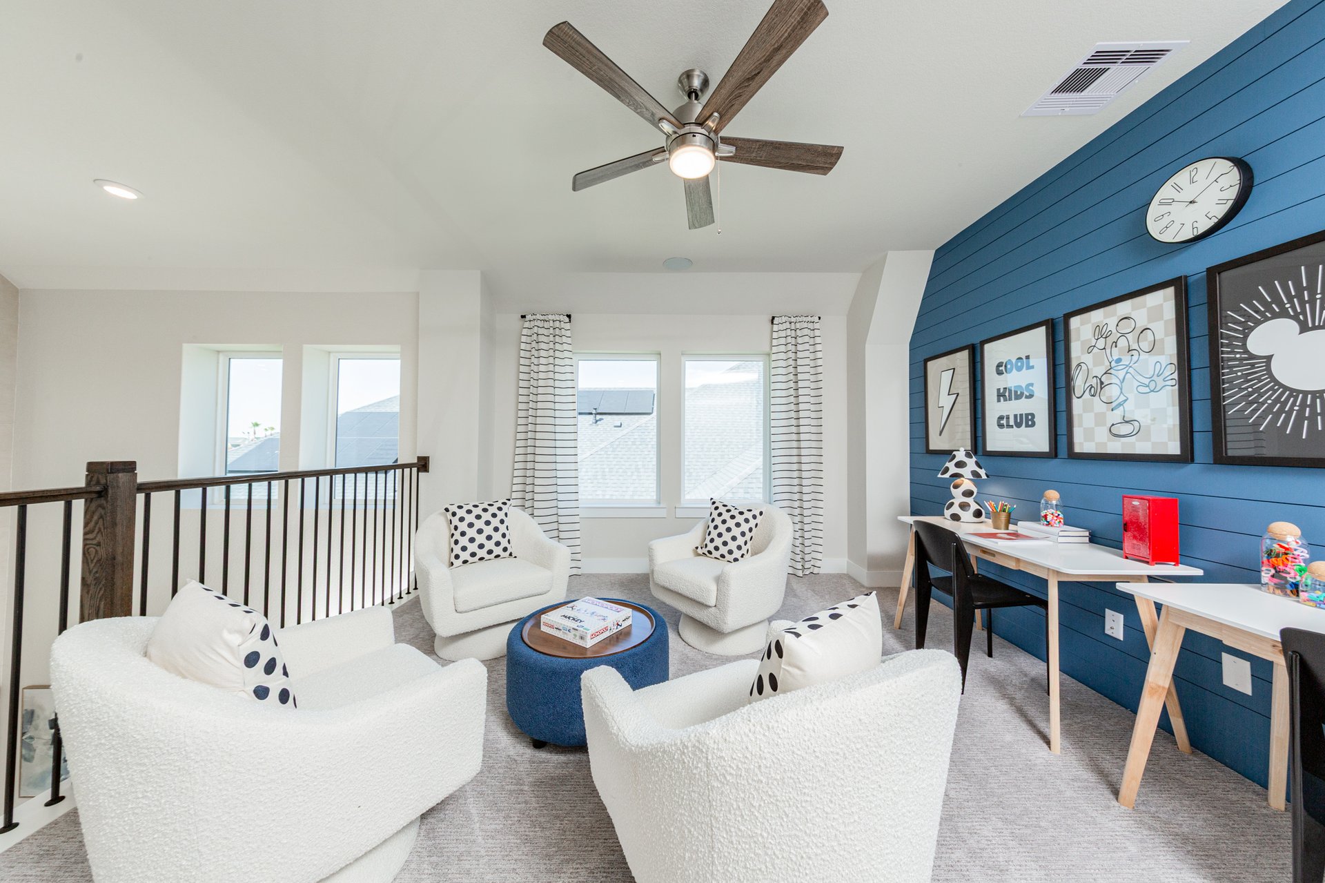 loft with ceiling fan and stair railing