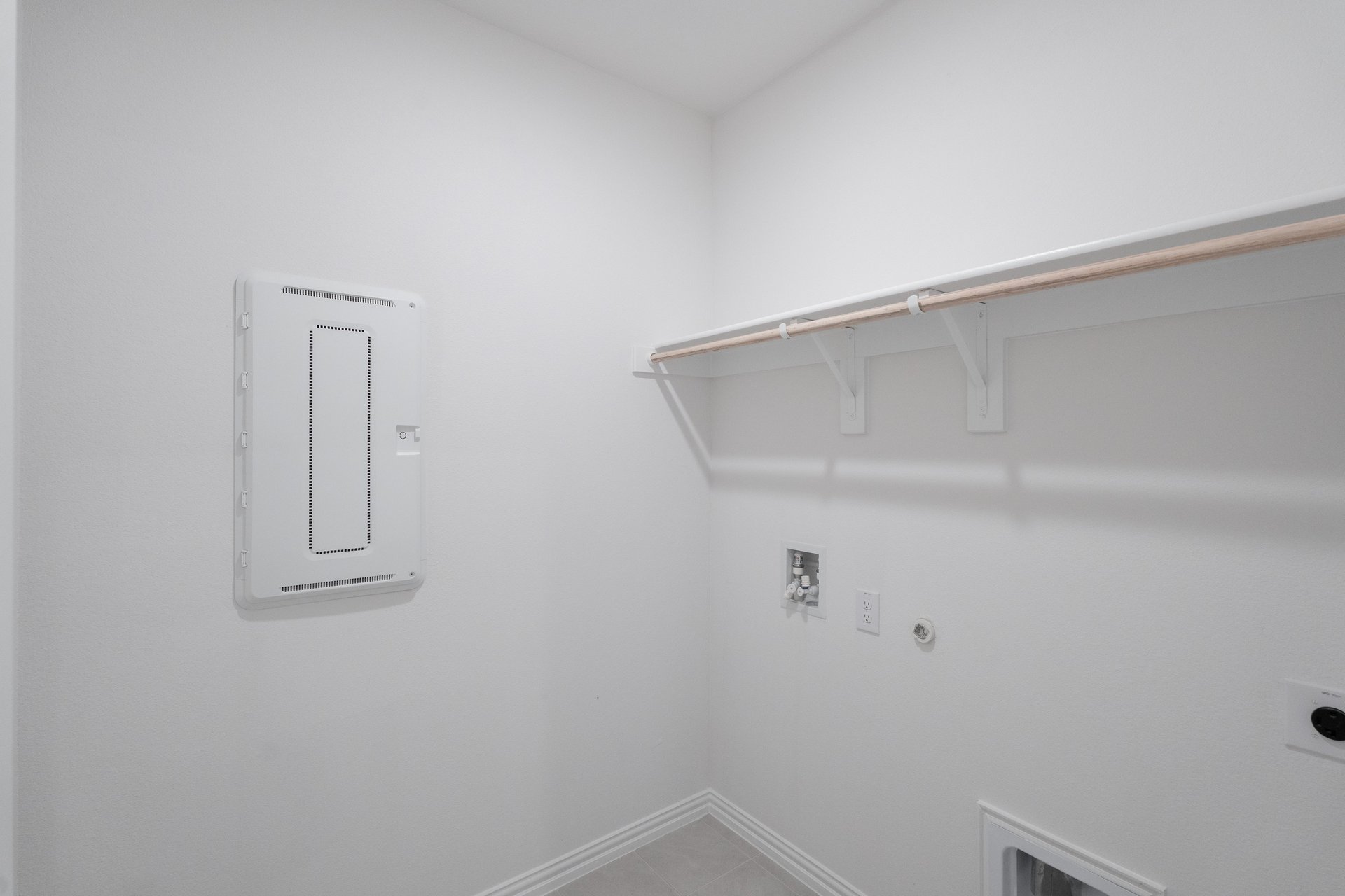 laundry room with tile floors and white shelf