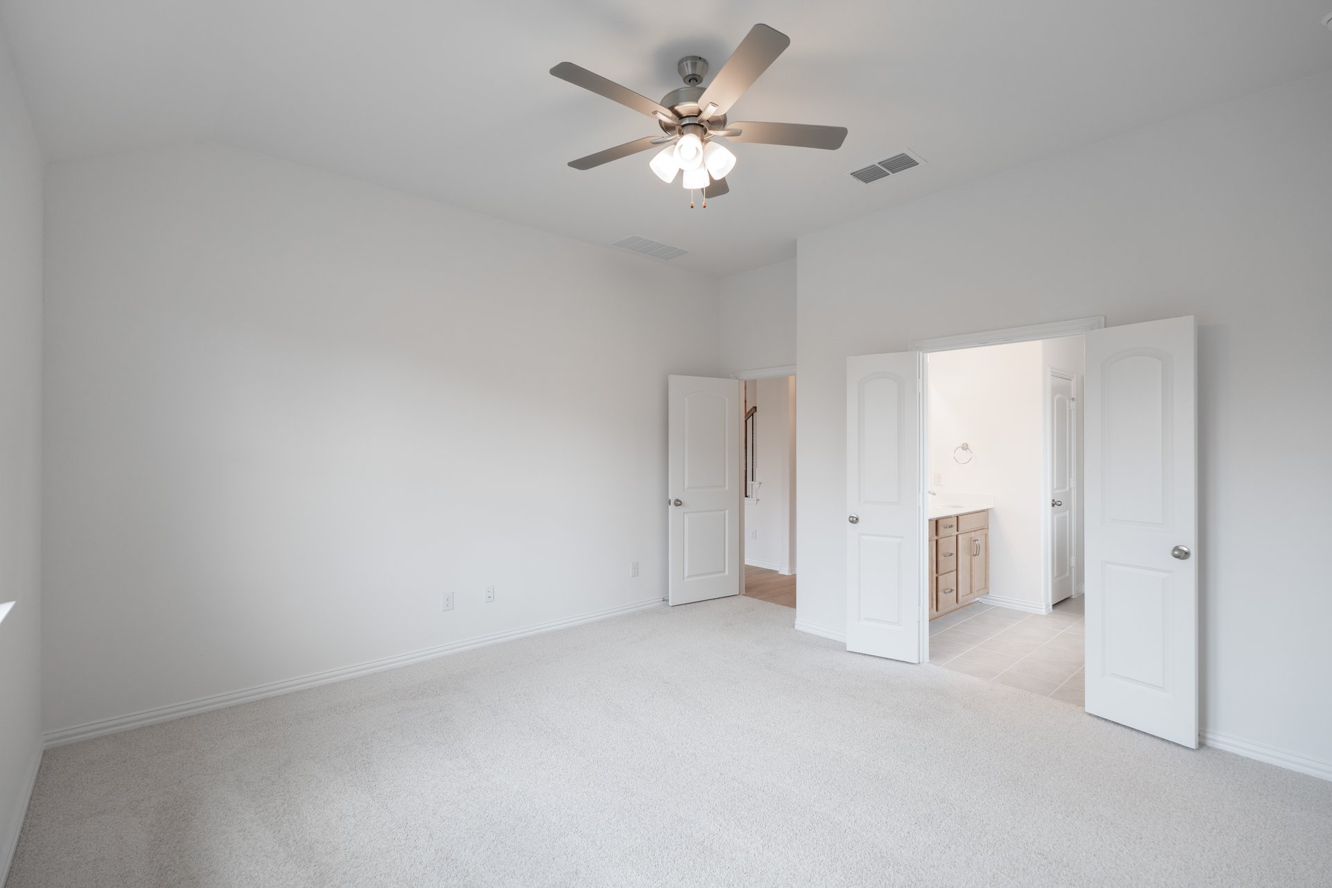 primary bedroom with carpet and ceiling fan