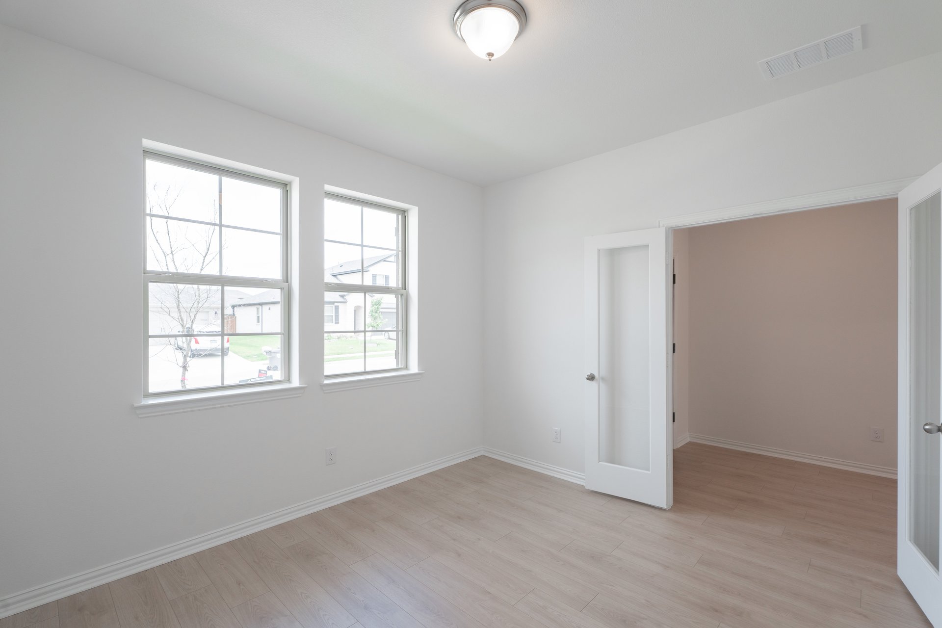 private study with wood floors and windows