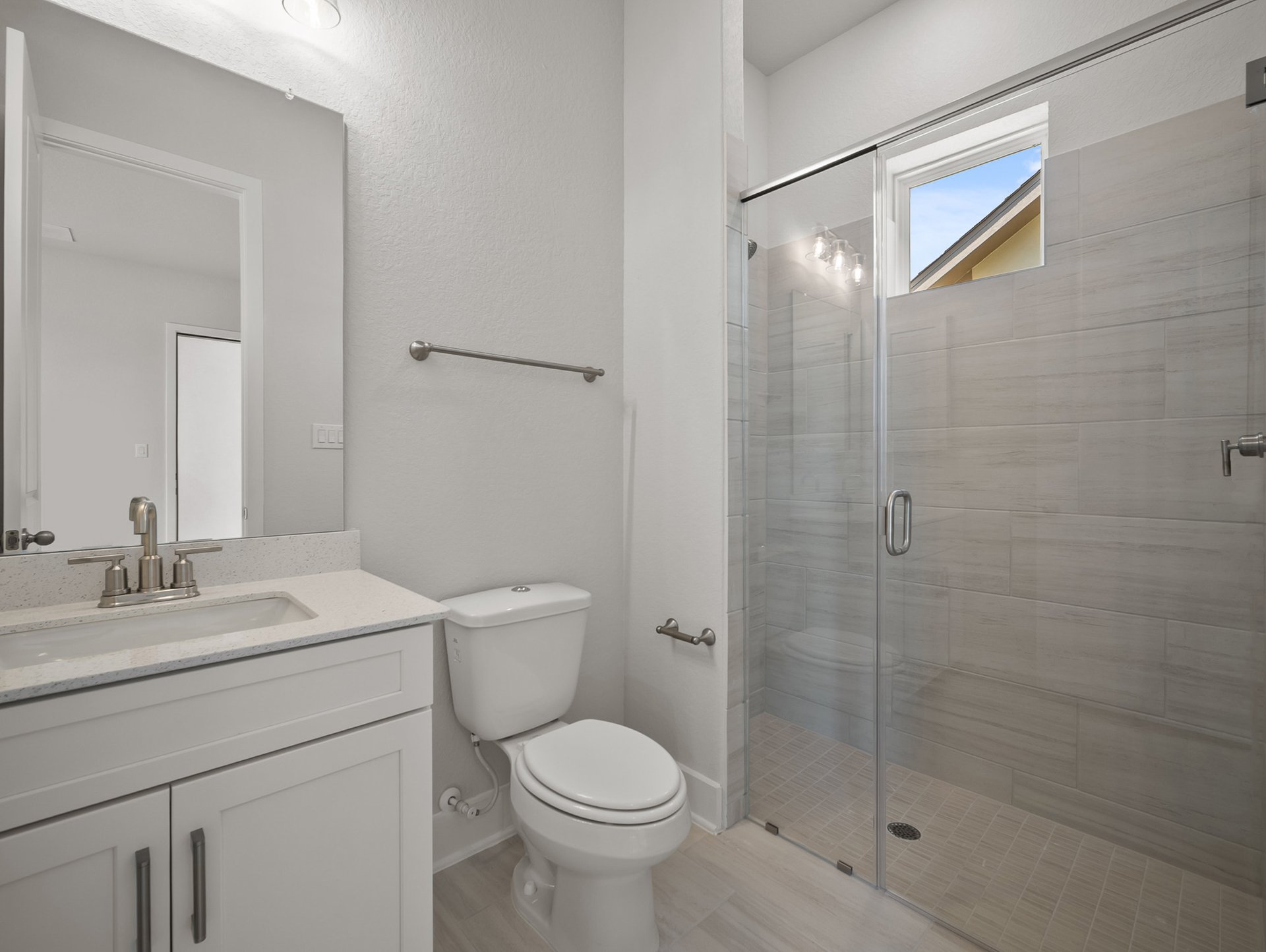 bathroom with quartz countertops & a walk-in shower