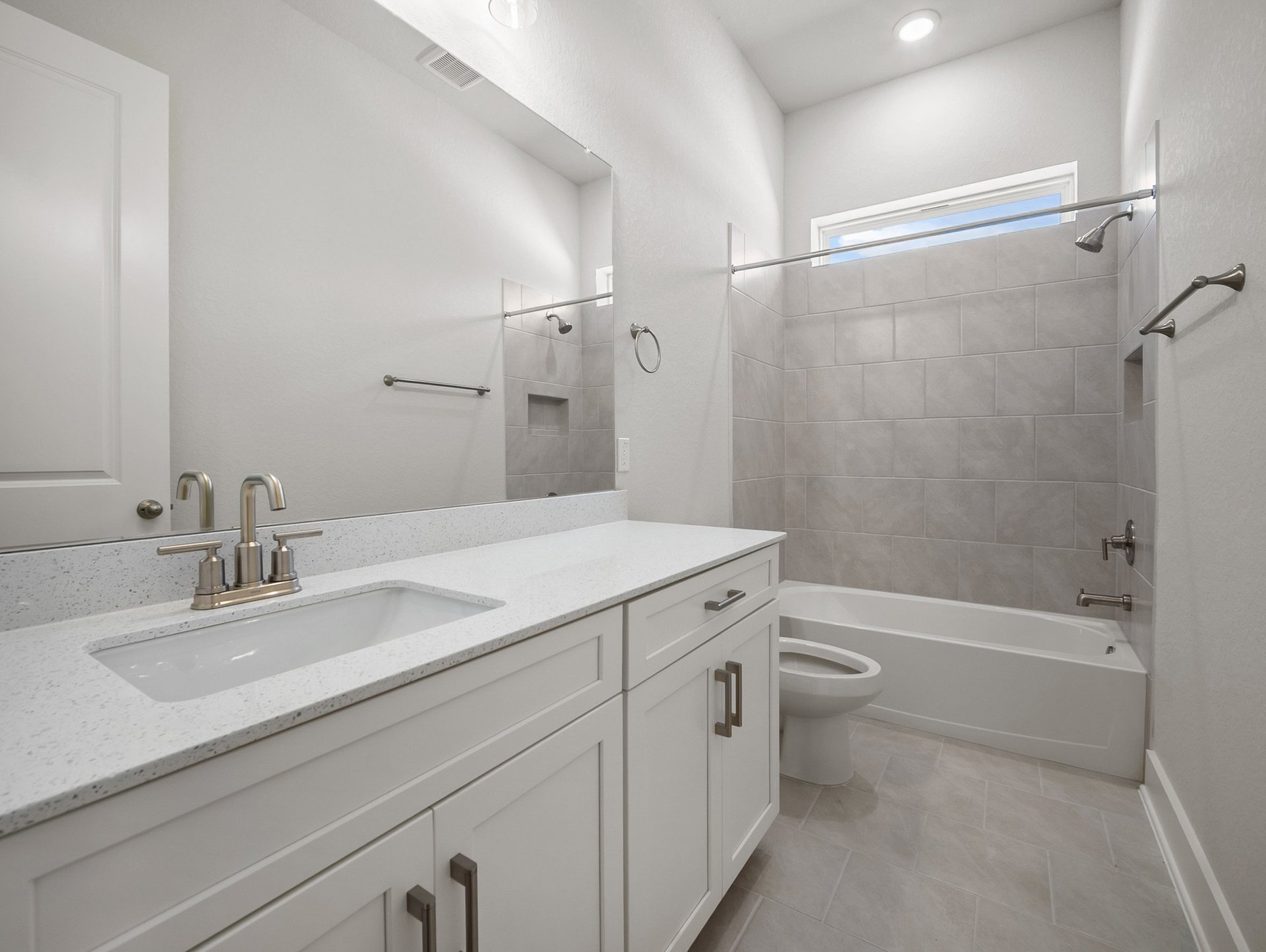 bathroom with quartz countertops & a bathtub with shower combo