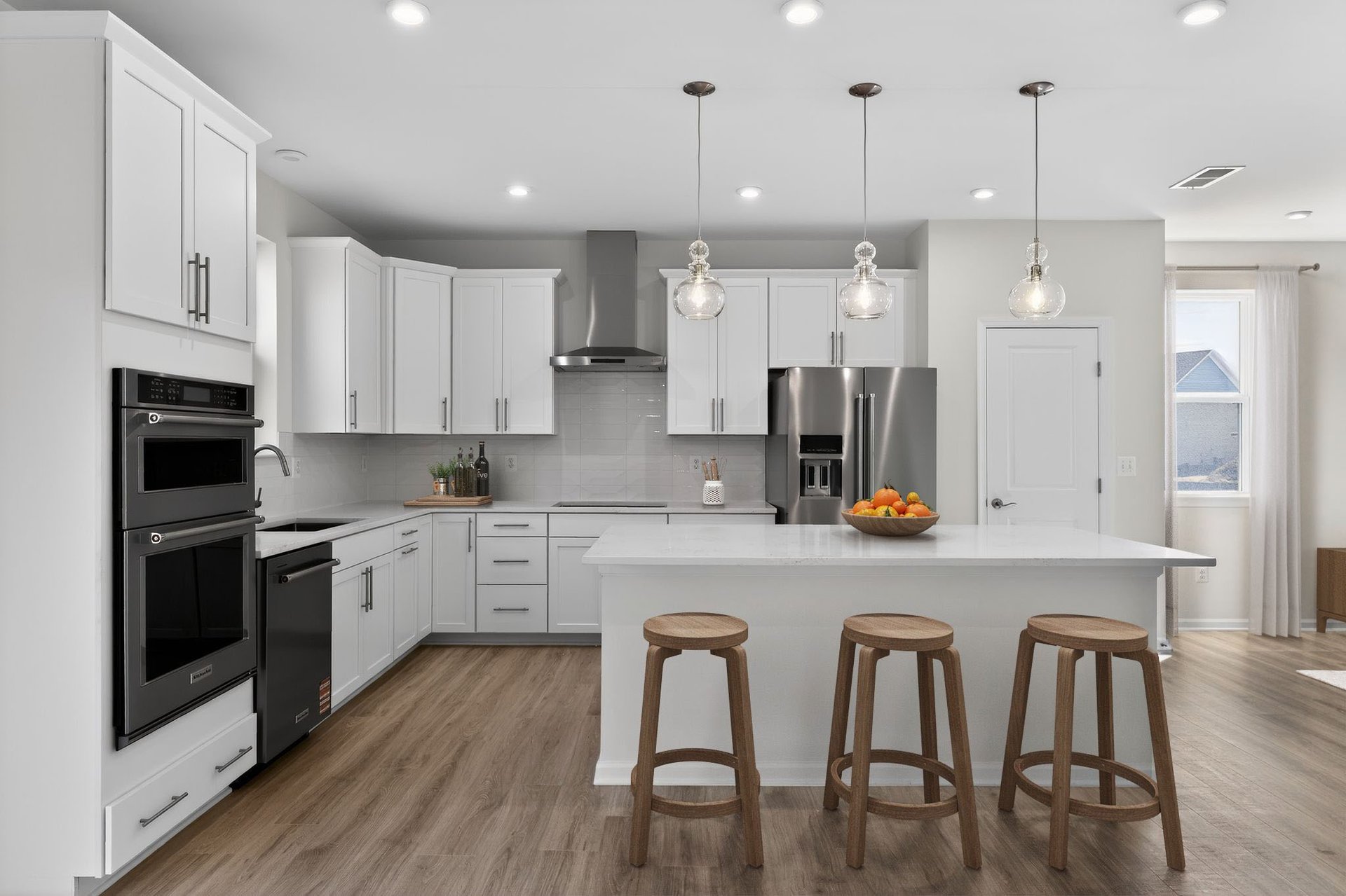bright kitchen with double-oven and pendant lighting above island