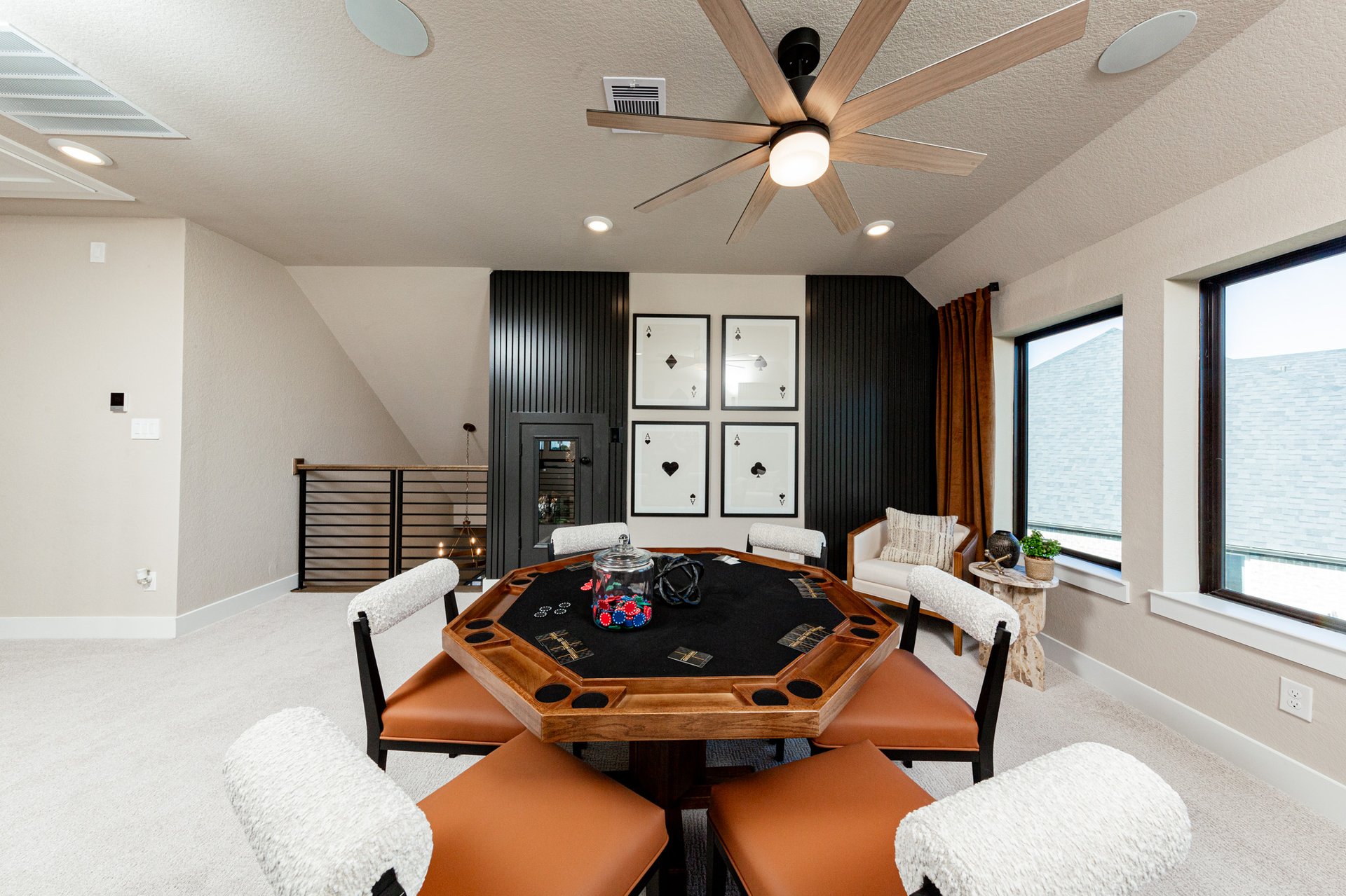 loft with two windows and ceiling fan 
