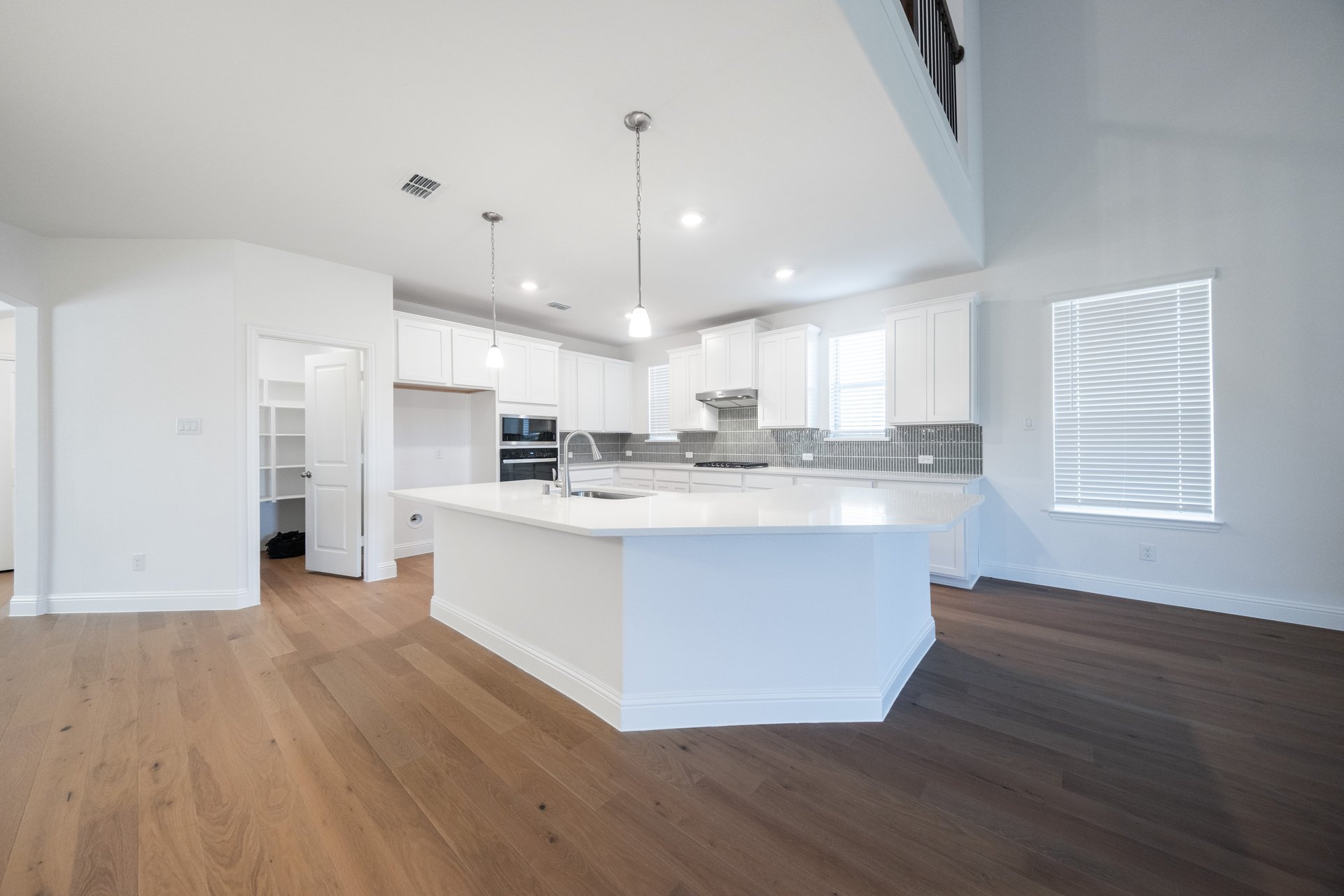 open kitchen with white cabinets and hardwood flooring