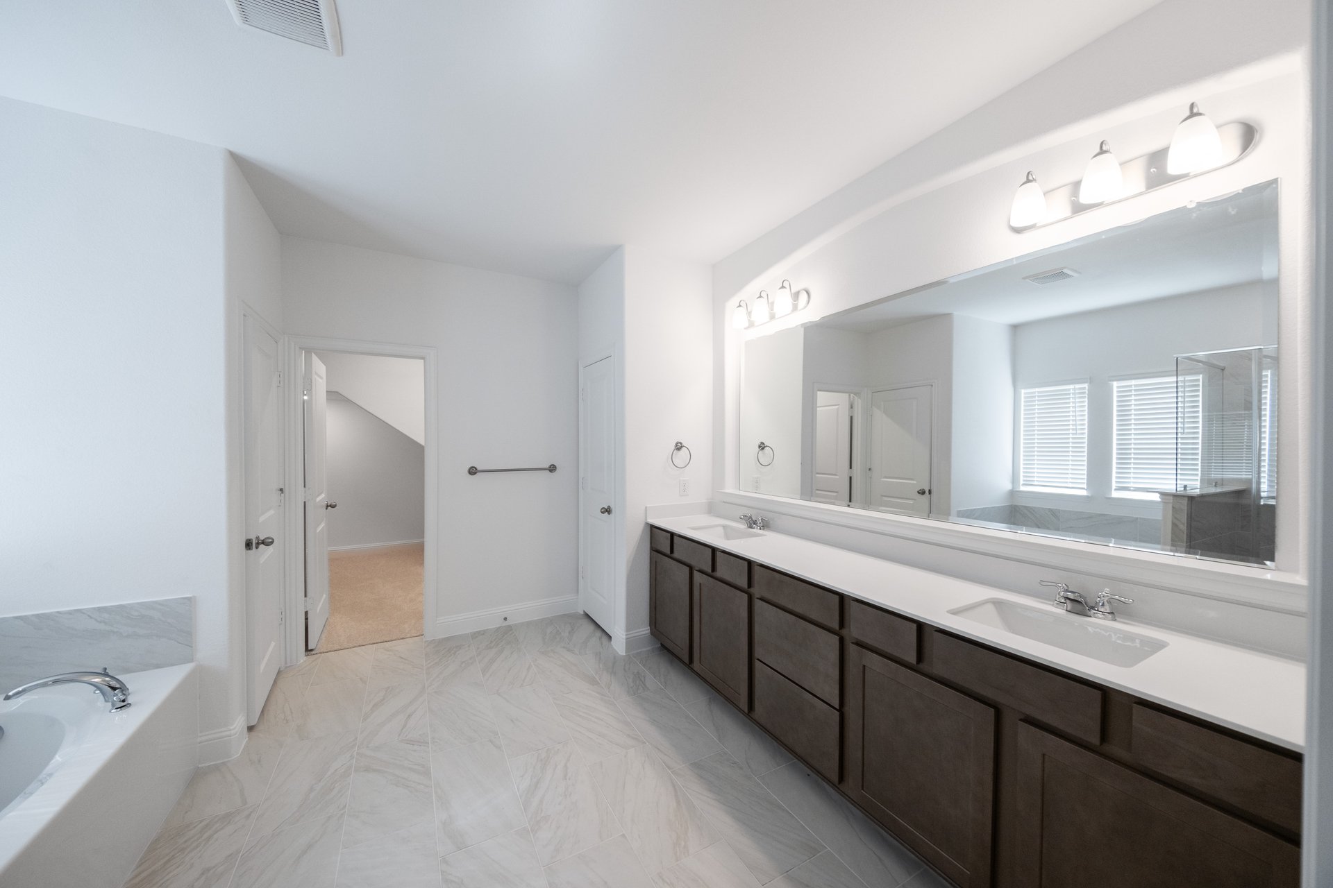 spacious primary bathroom with tile flooring