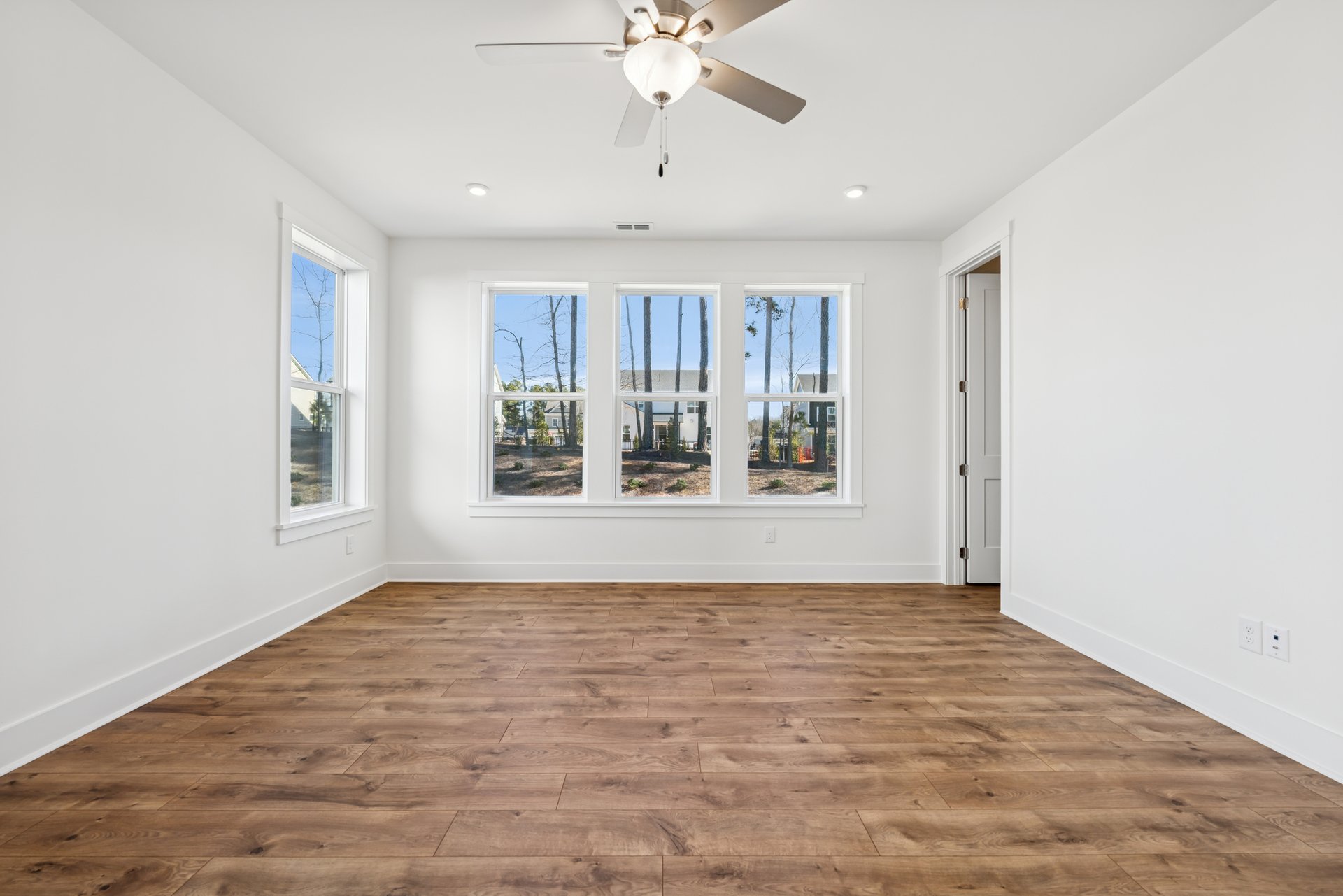 primary bedroom with several windows and a ceiling fan