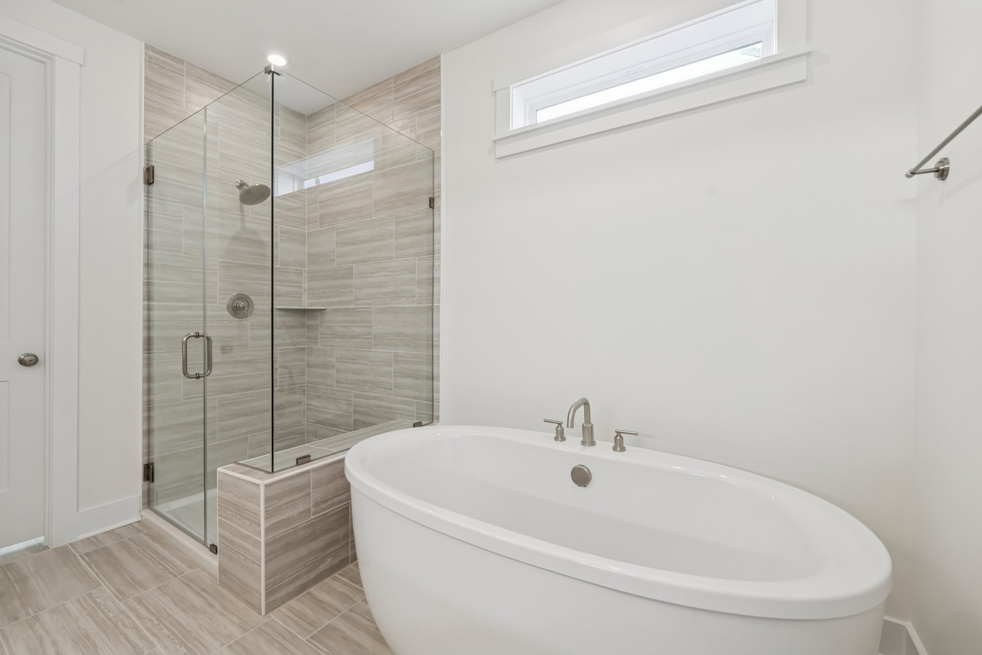 primary bathroom with shower, bathtub and a window