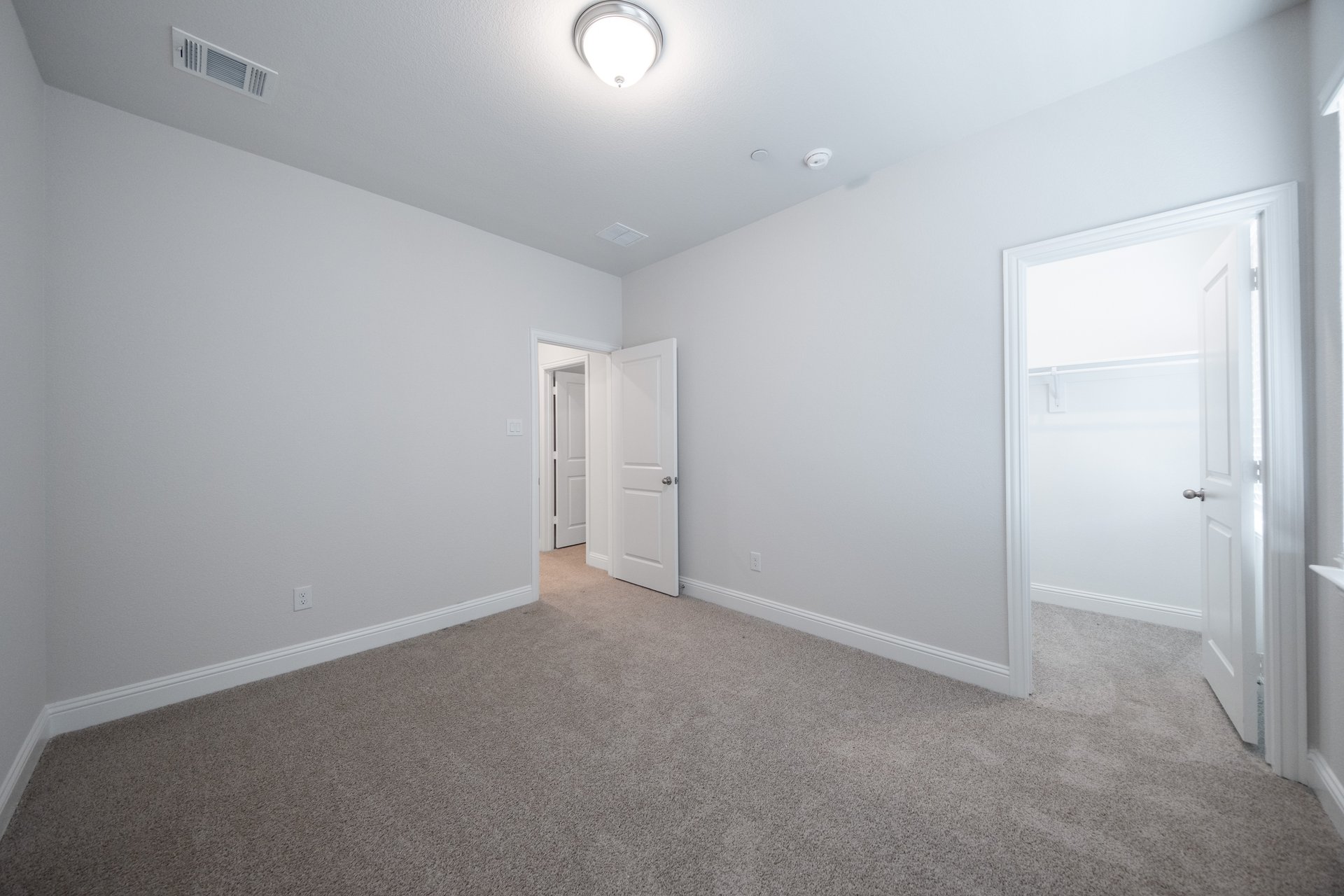 guest bedroom with carpet and walk-in closet