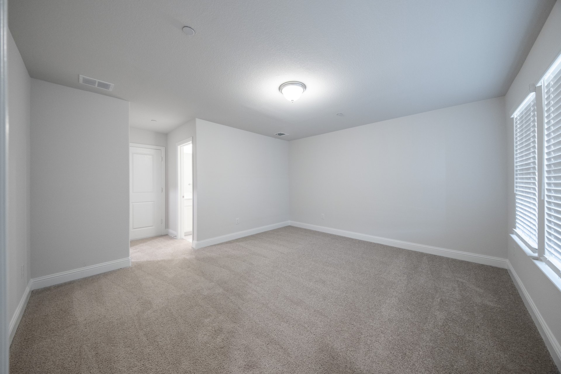 guest bedroom with carpet and attached bathroom