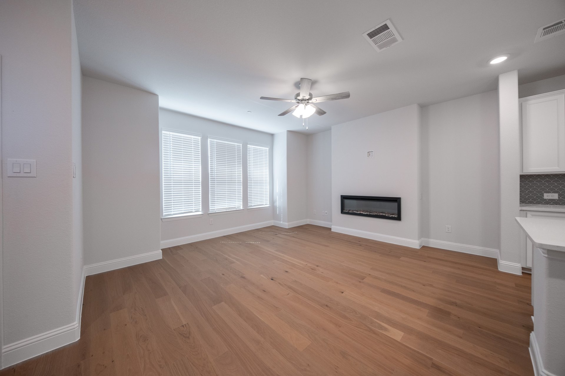 open great room with electric fireplace and hardwood flooring