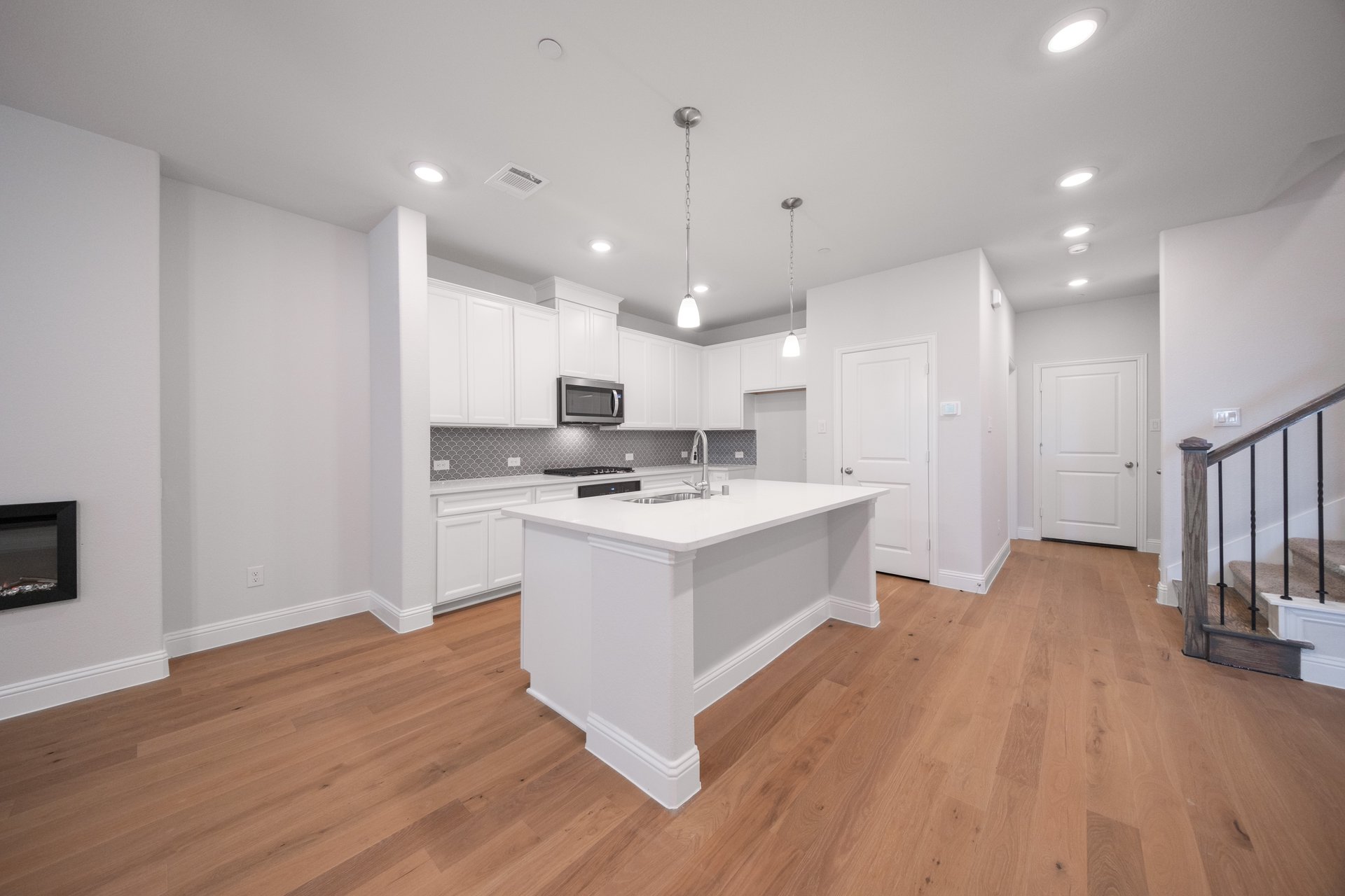 open kitchen with white cabinets and hardwood flooring