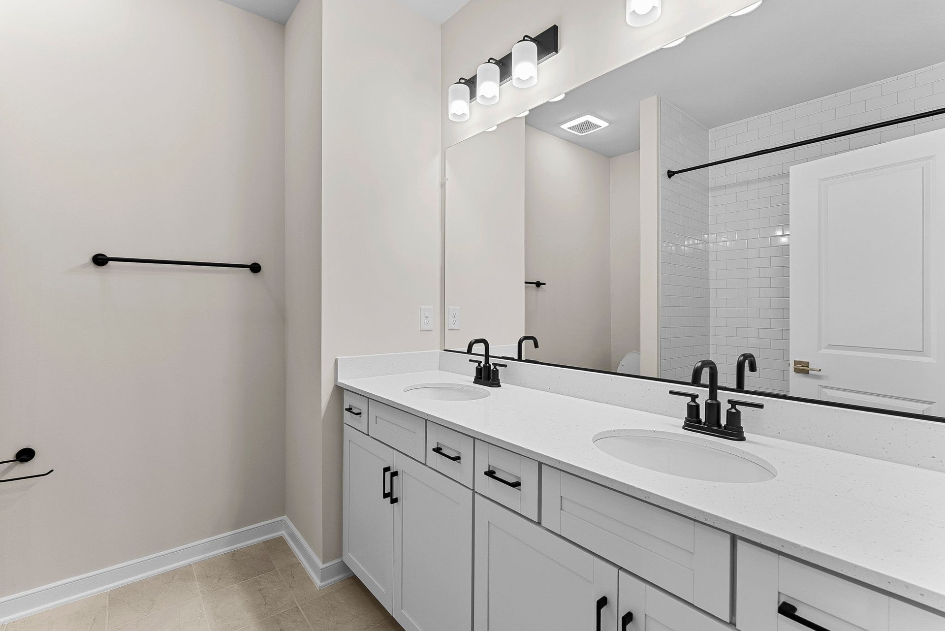 first-floor full bathroom with two sinks and a shower