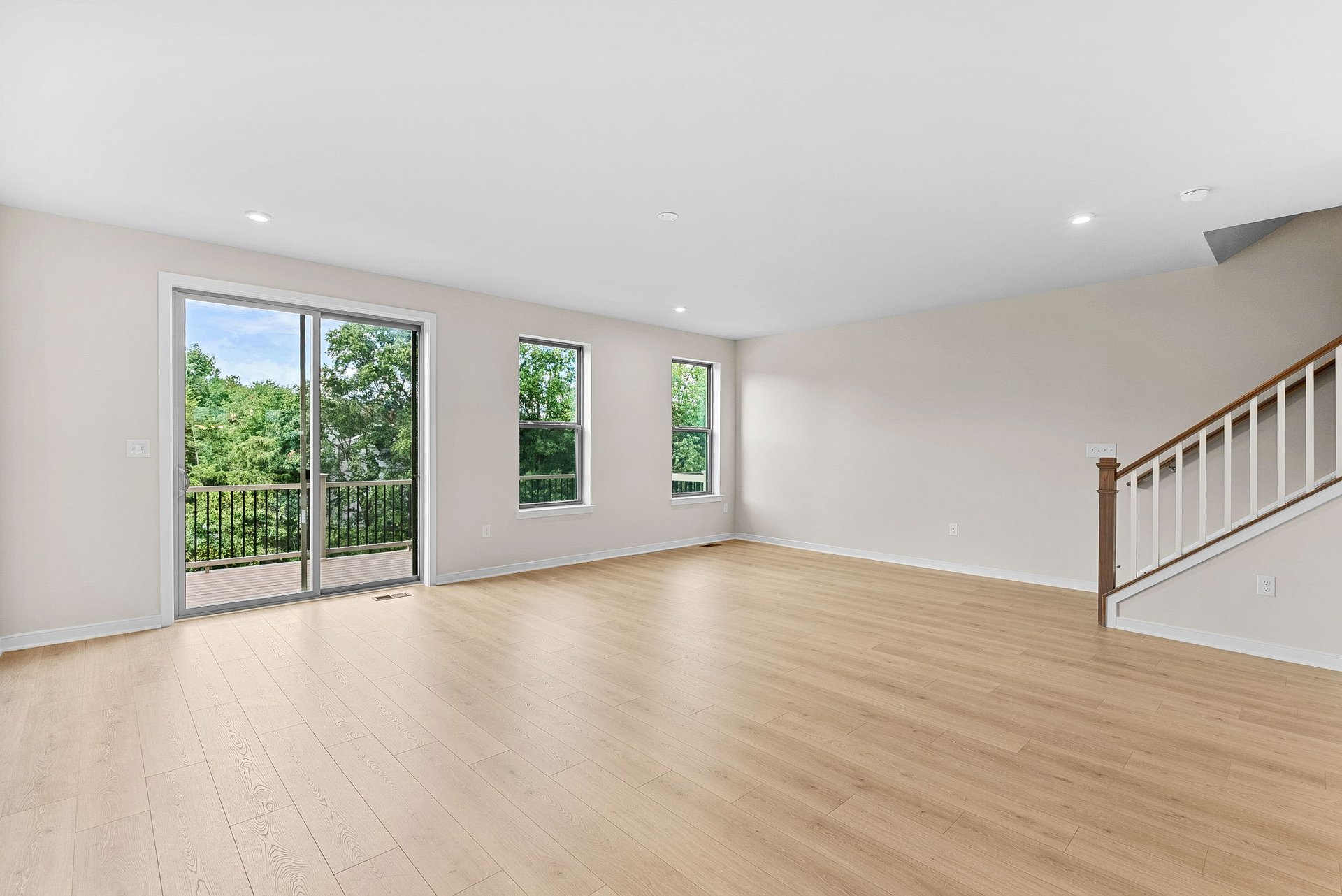 great room with two windows and a sliding glass door to the deck