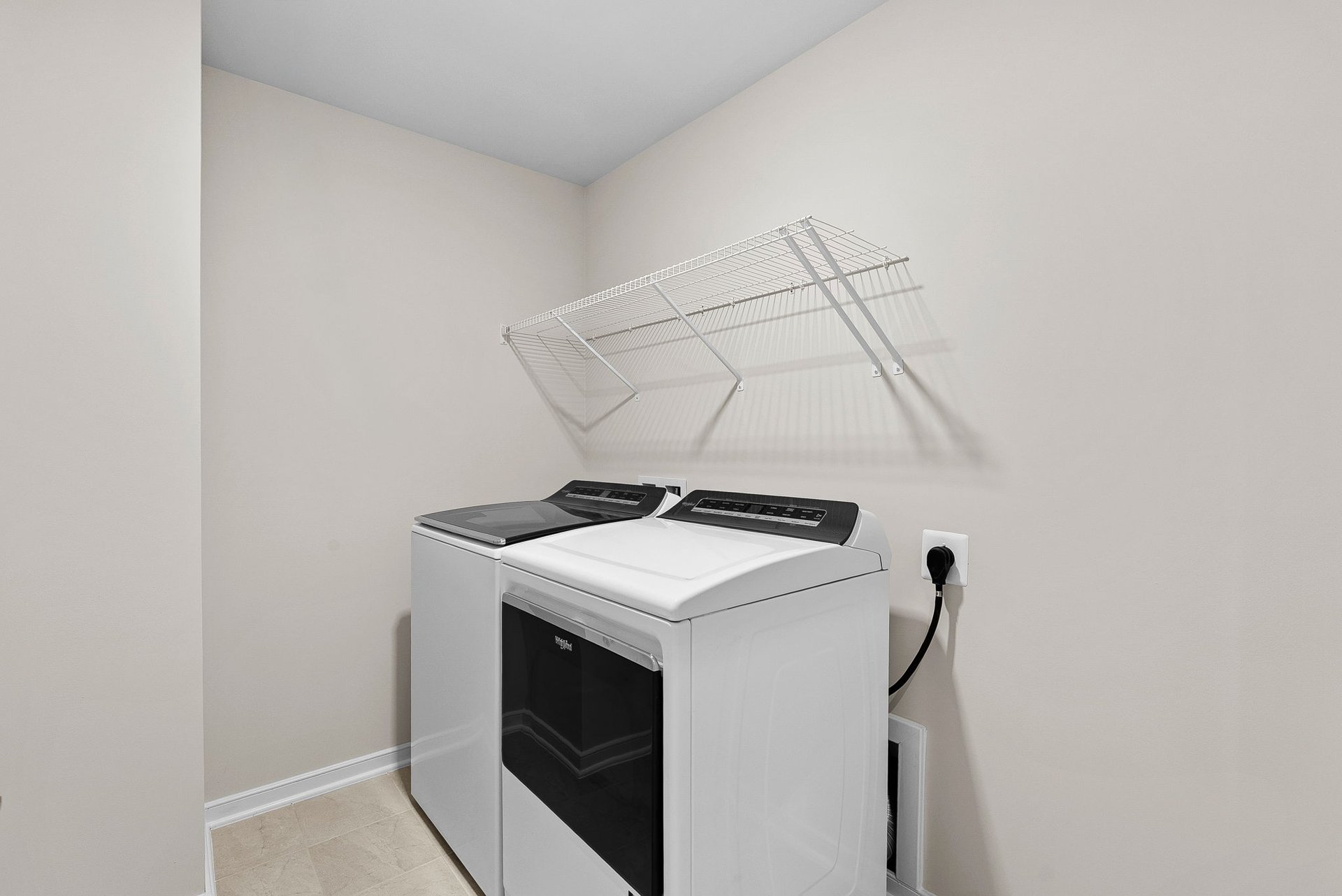 laundry room with washer, dryer and a wire shelf