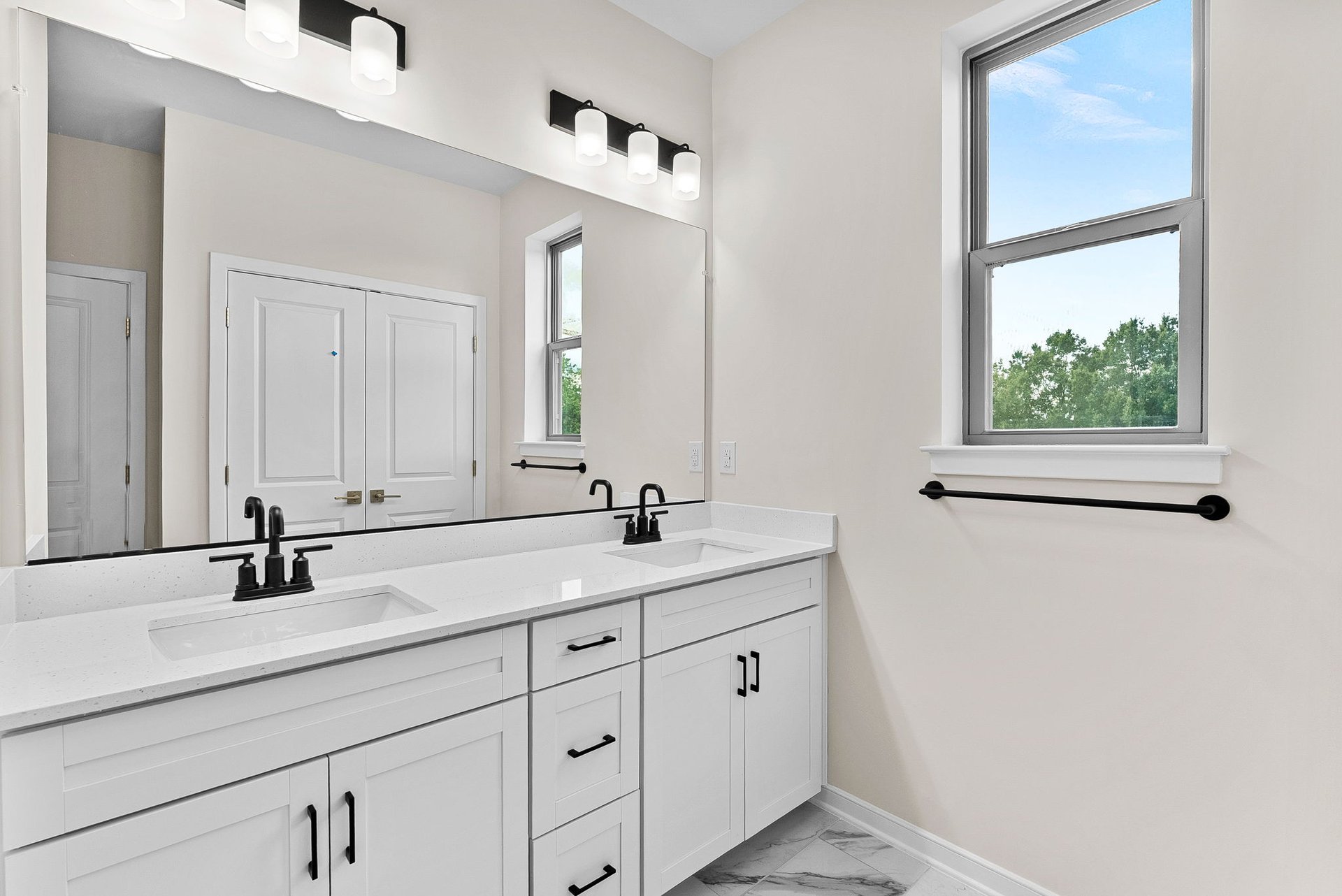 primary bathroom with two sinks and a window